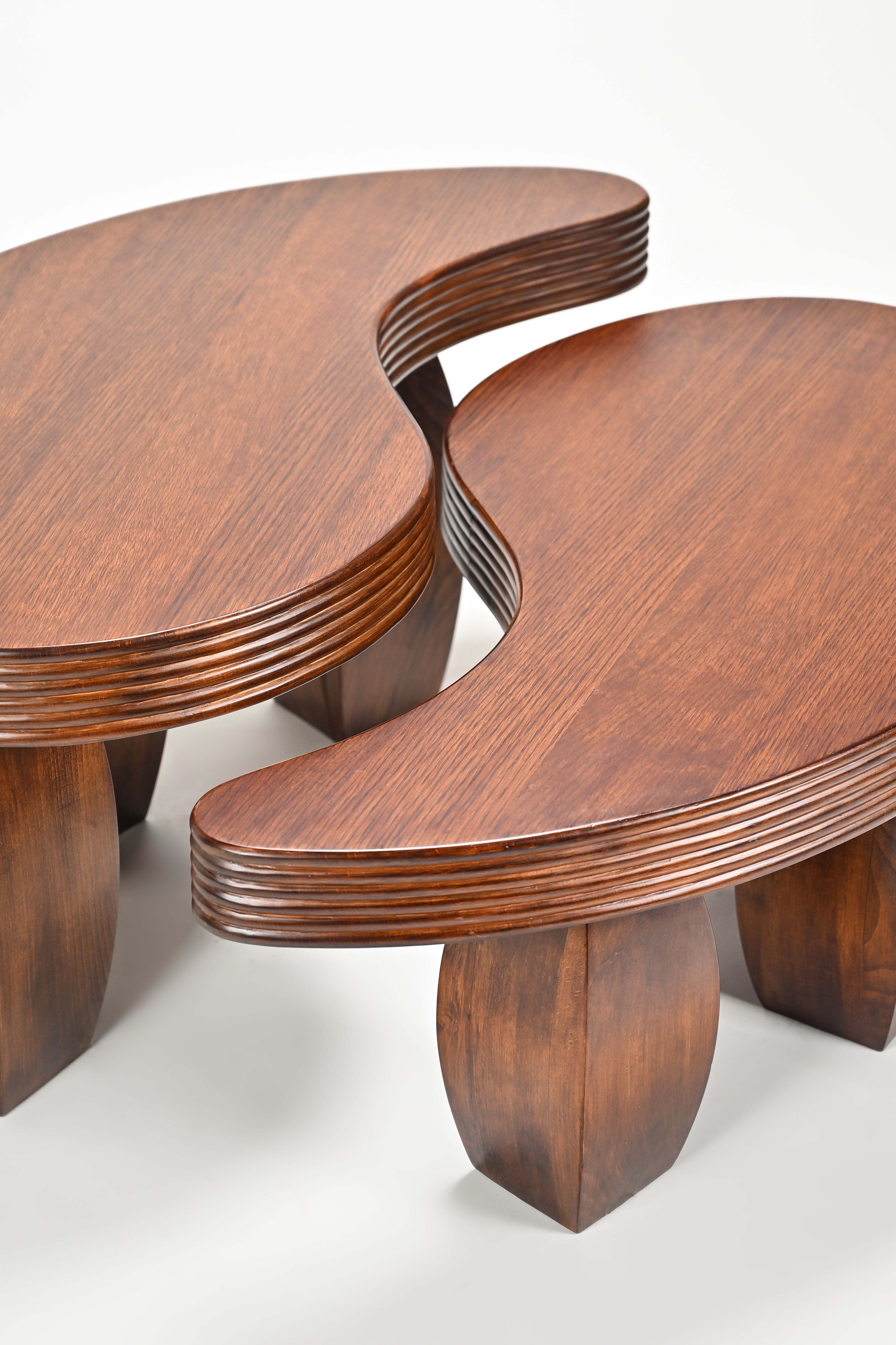 Two wooden tables with a modern design on a white background
