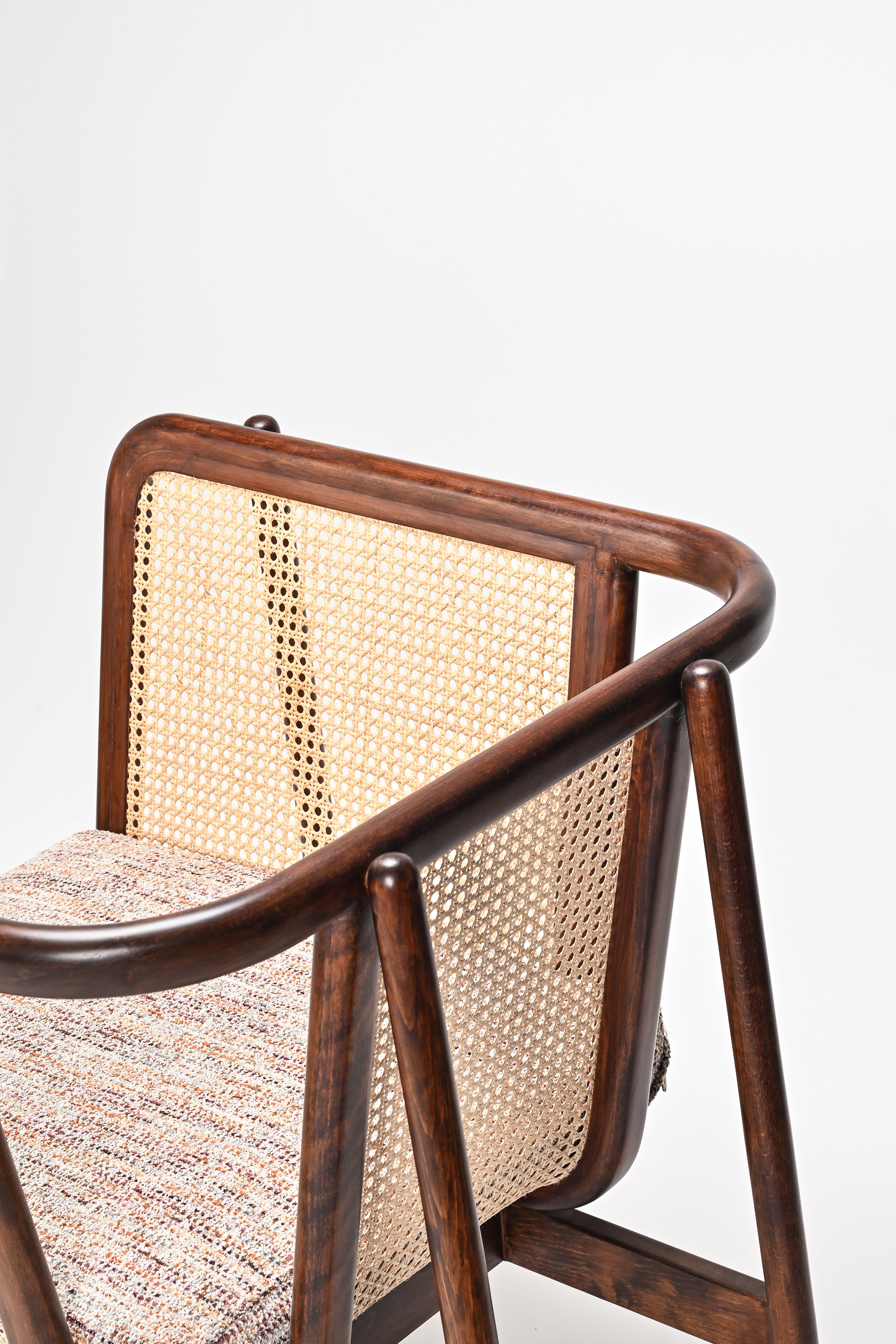 Chair with wooden frame and woven backrest on a white background