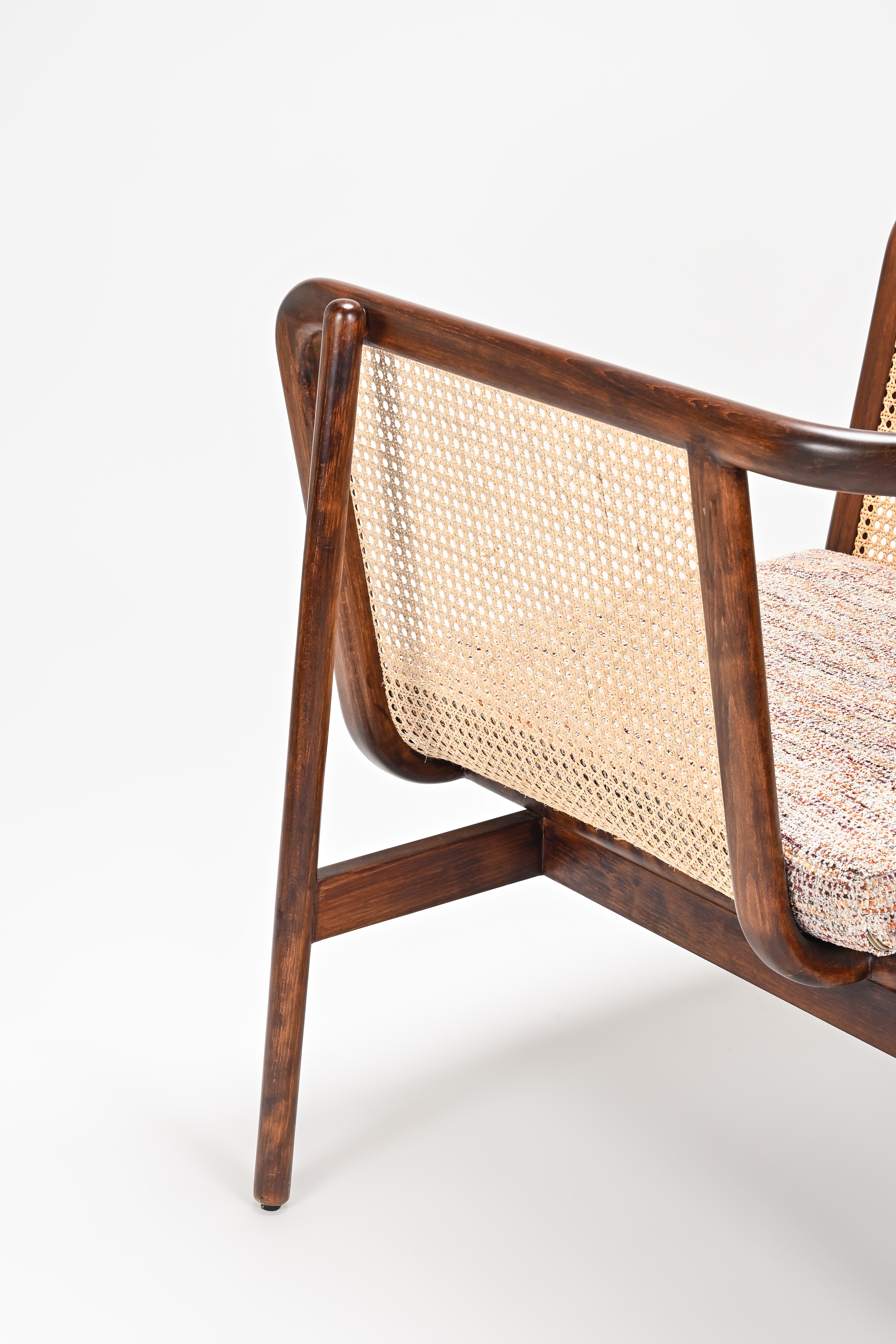 Close-up of a wooden armchair with woven backrest on a white background