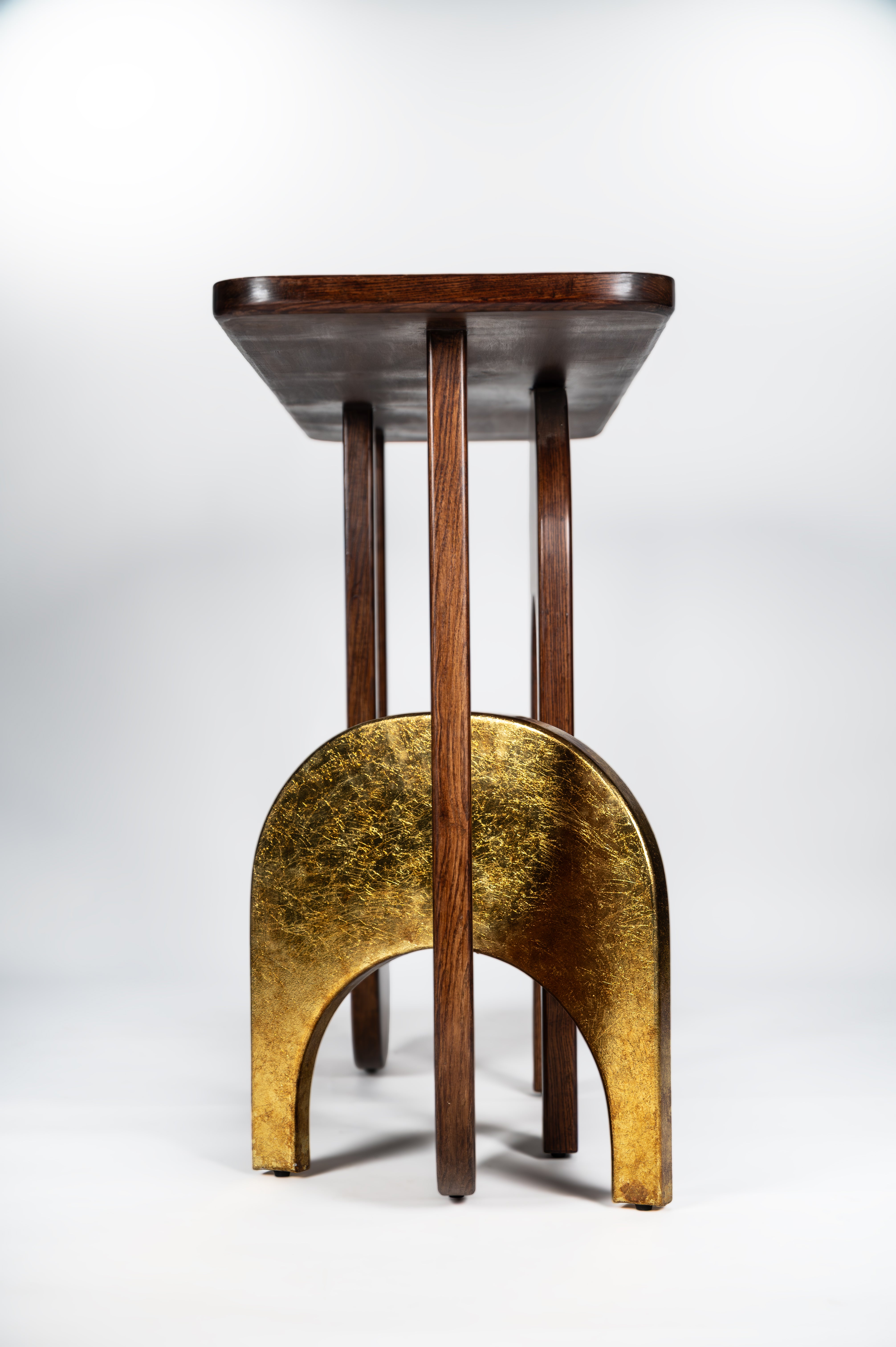 Wooden stool with a brass base on a white background