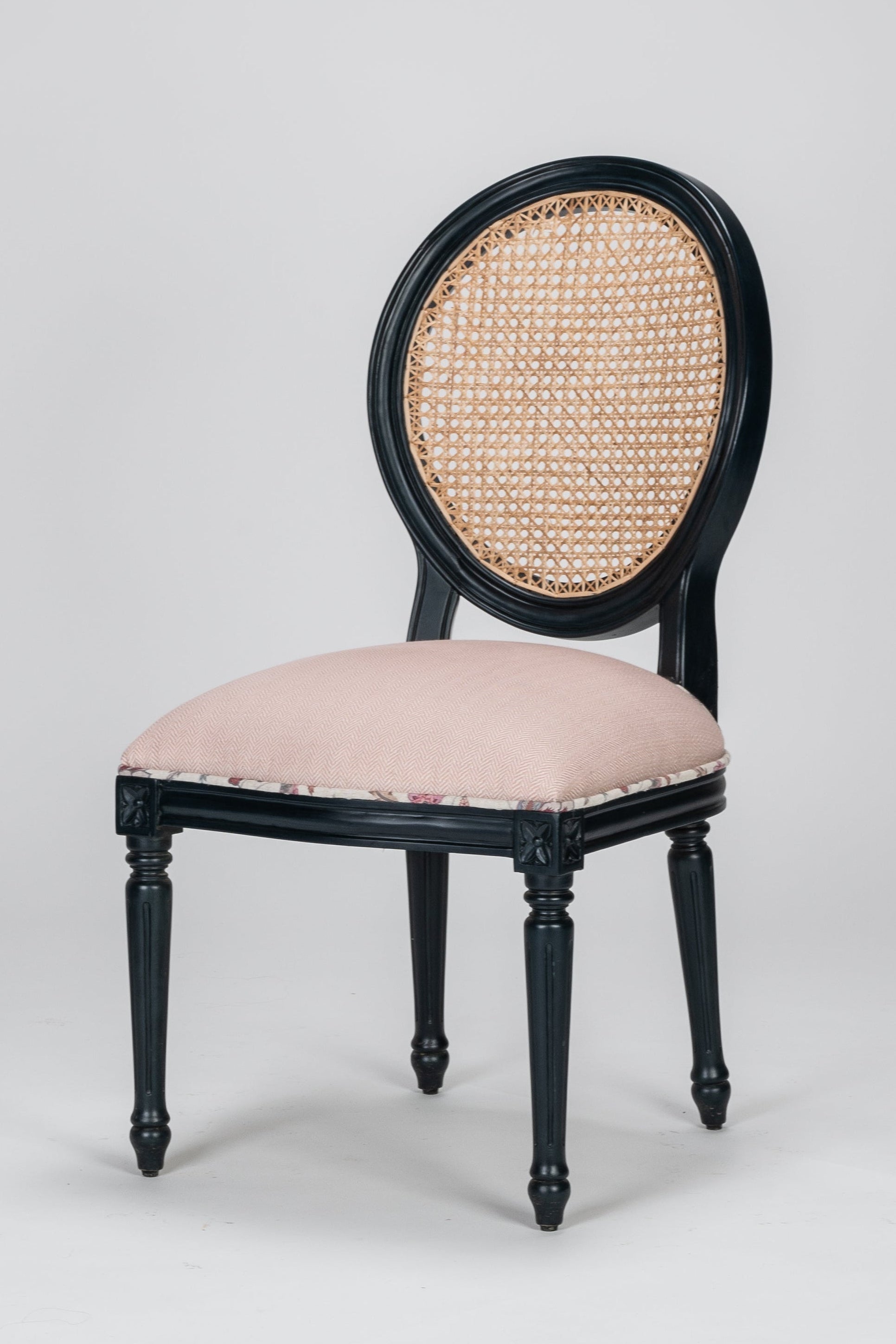 Chair with black frame and pink cushion on a gray background