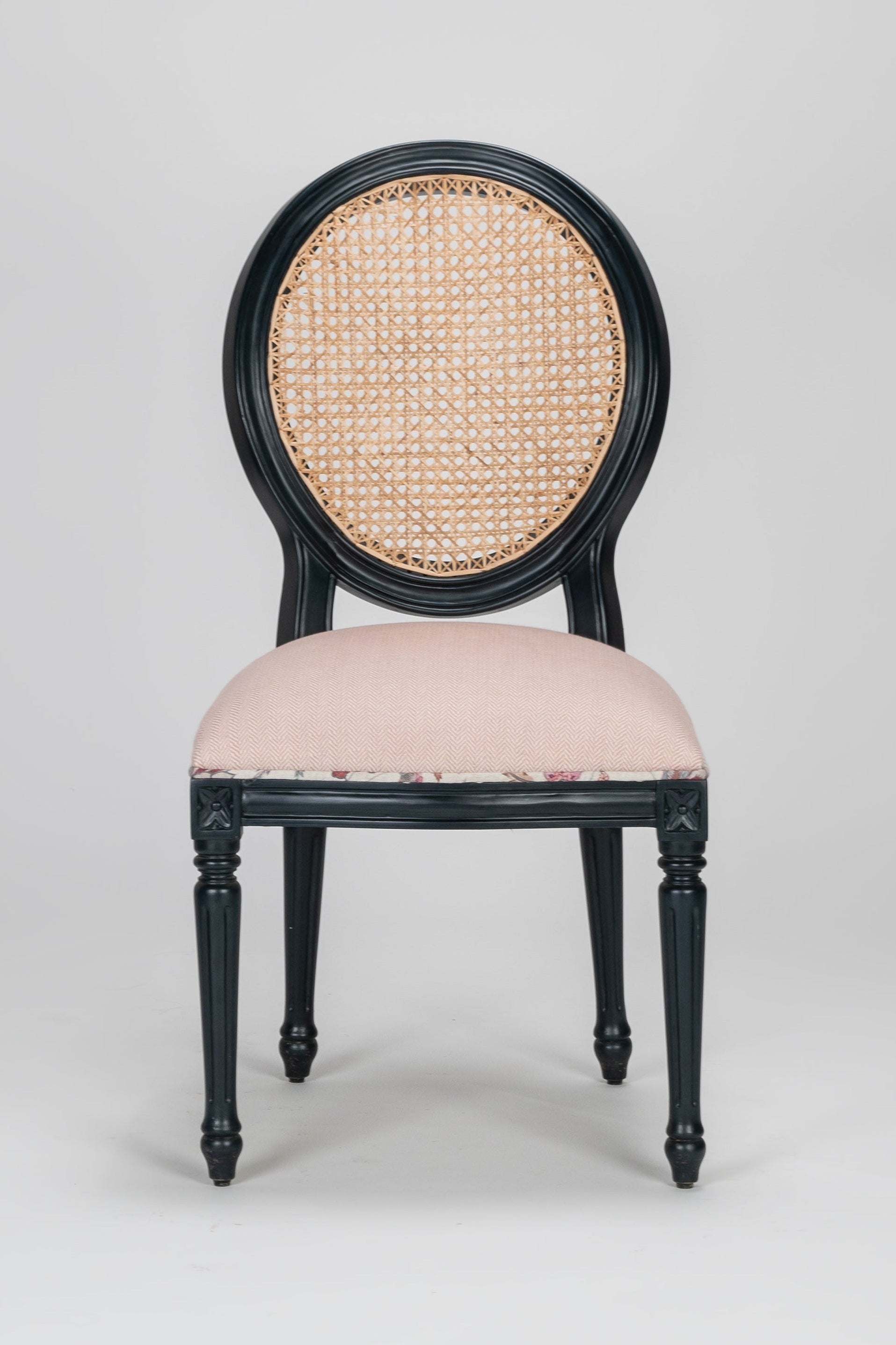 Chair with black frame and beige cushion on a gray background