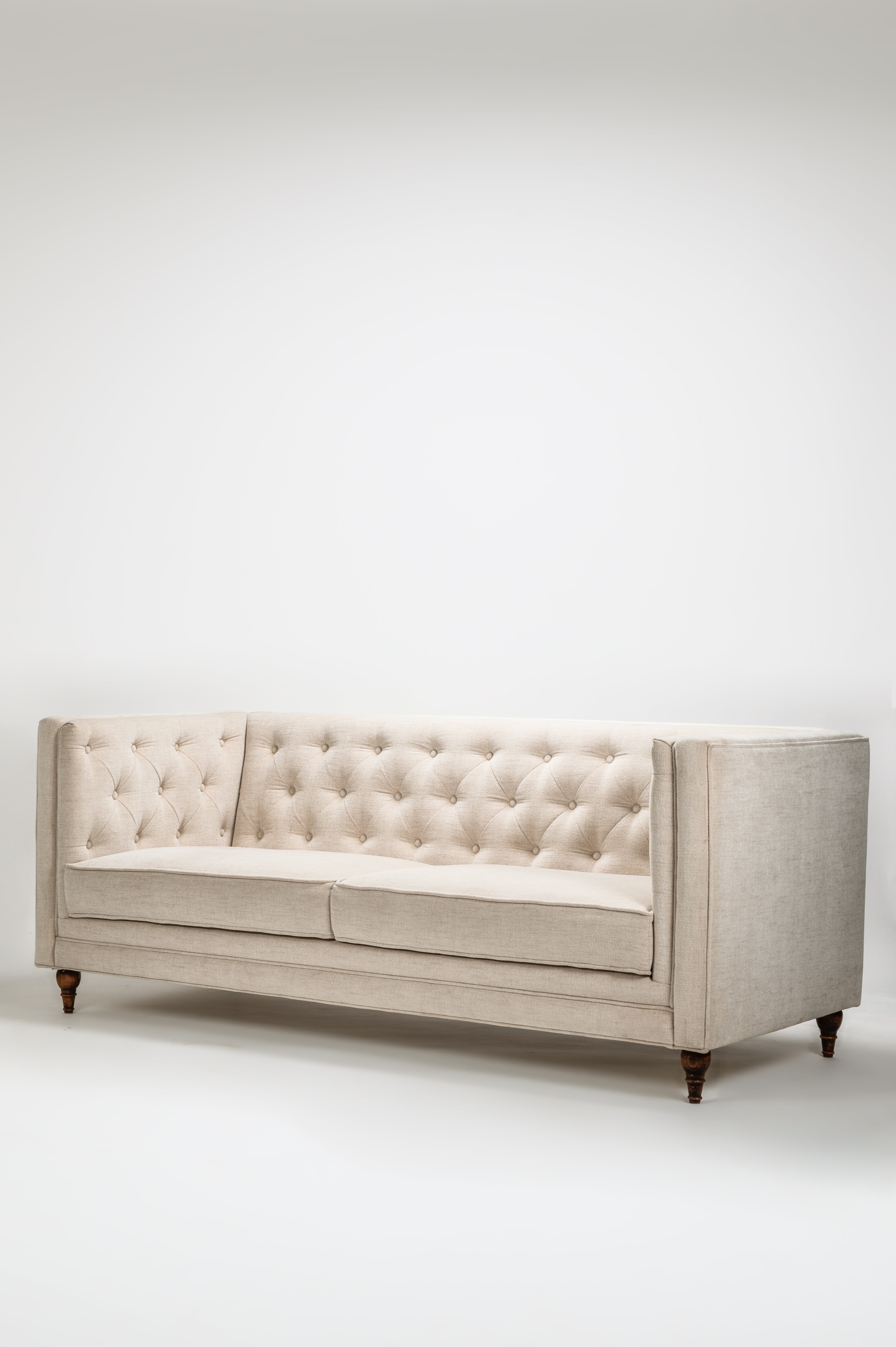 Beige tufted sofa on a white background
