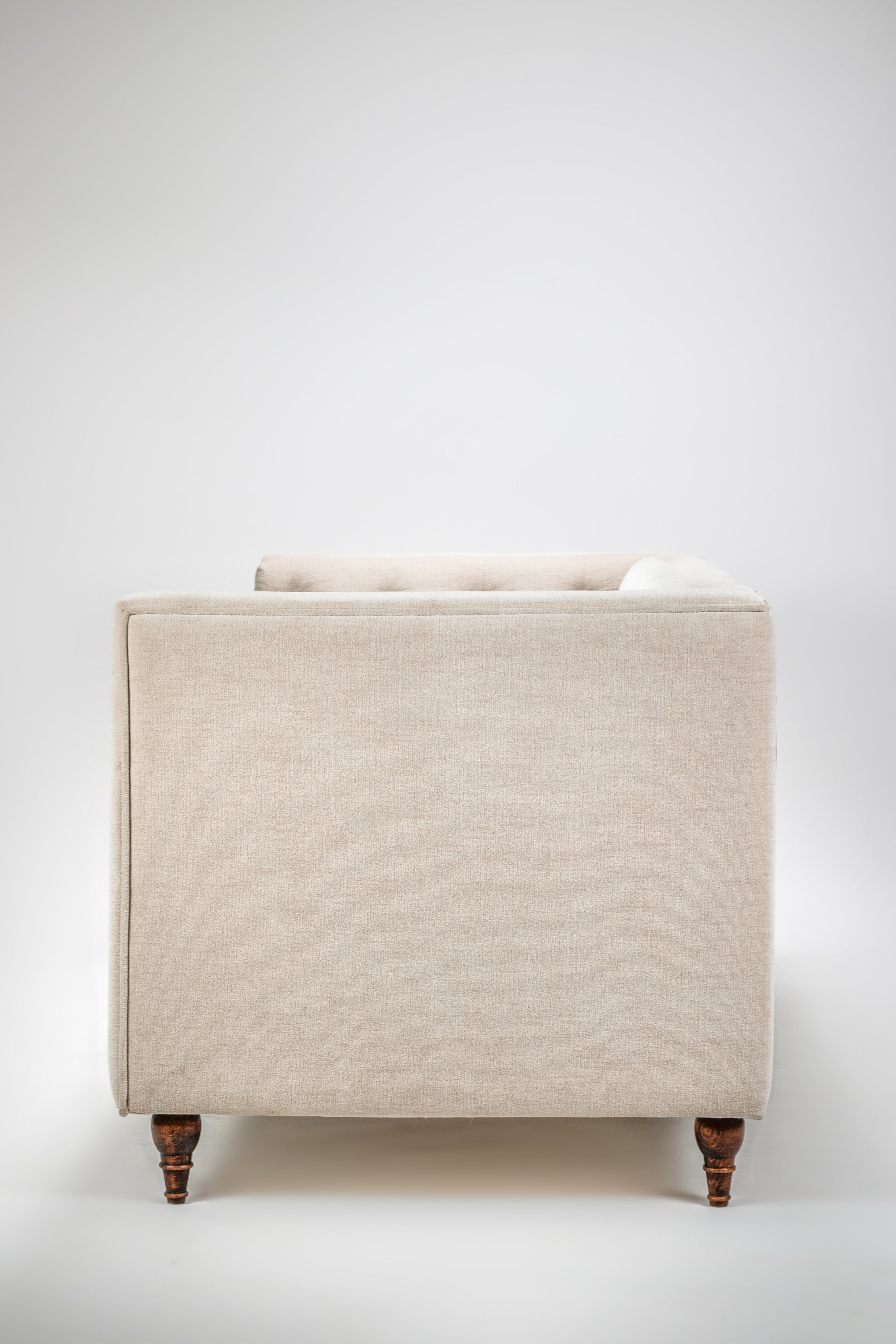 Beige armchair with wooden legs on a white background