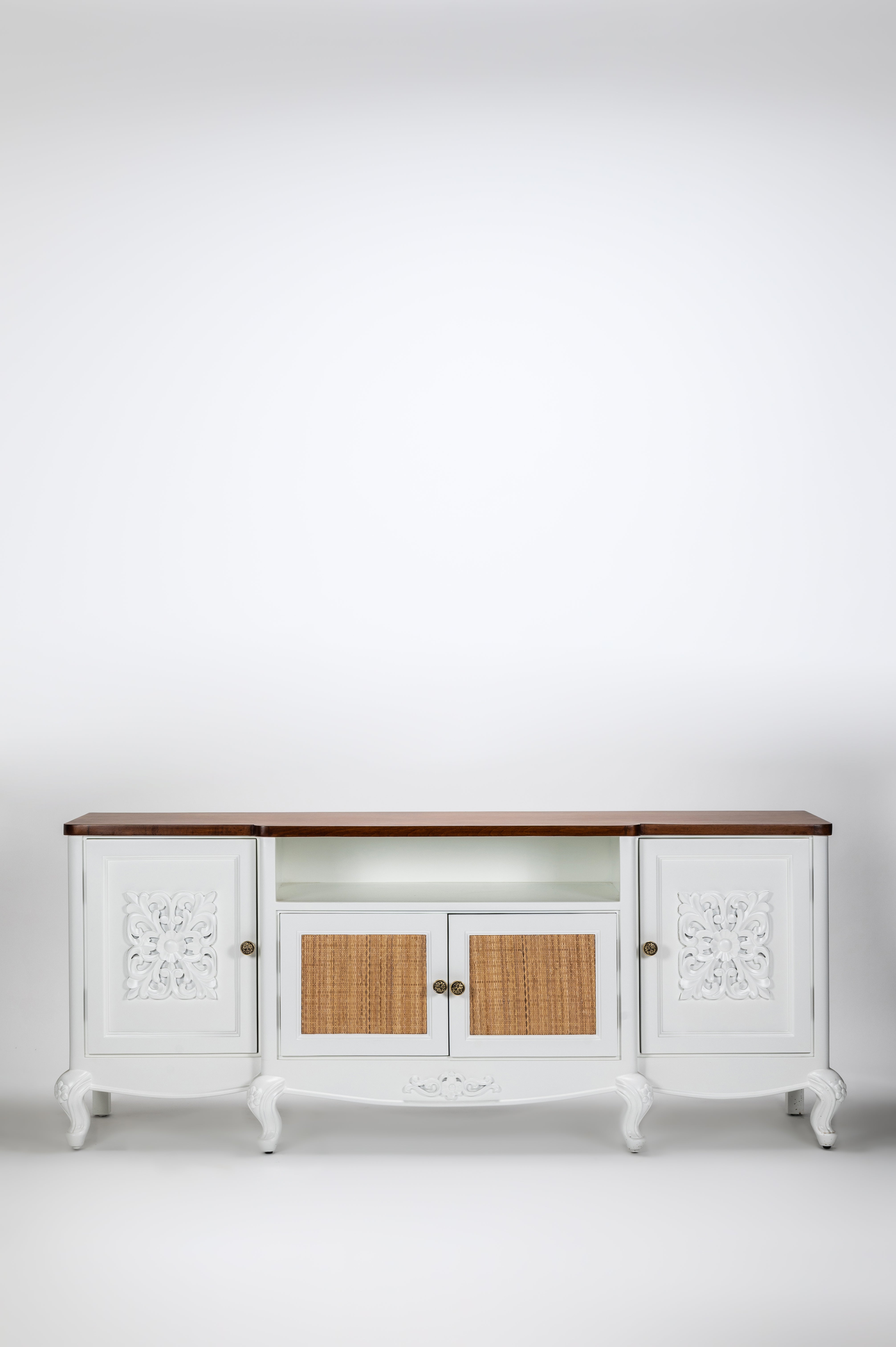 White sideboard with wooden top and wicker doors on a white background