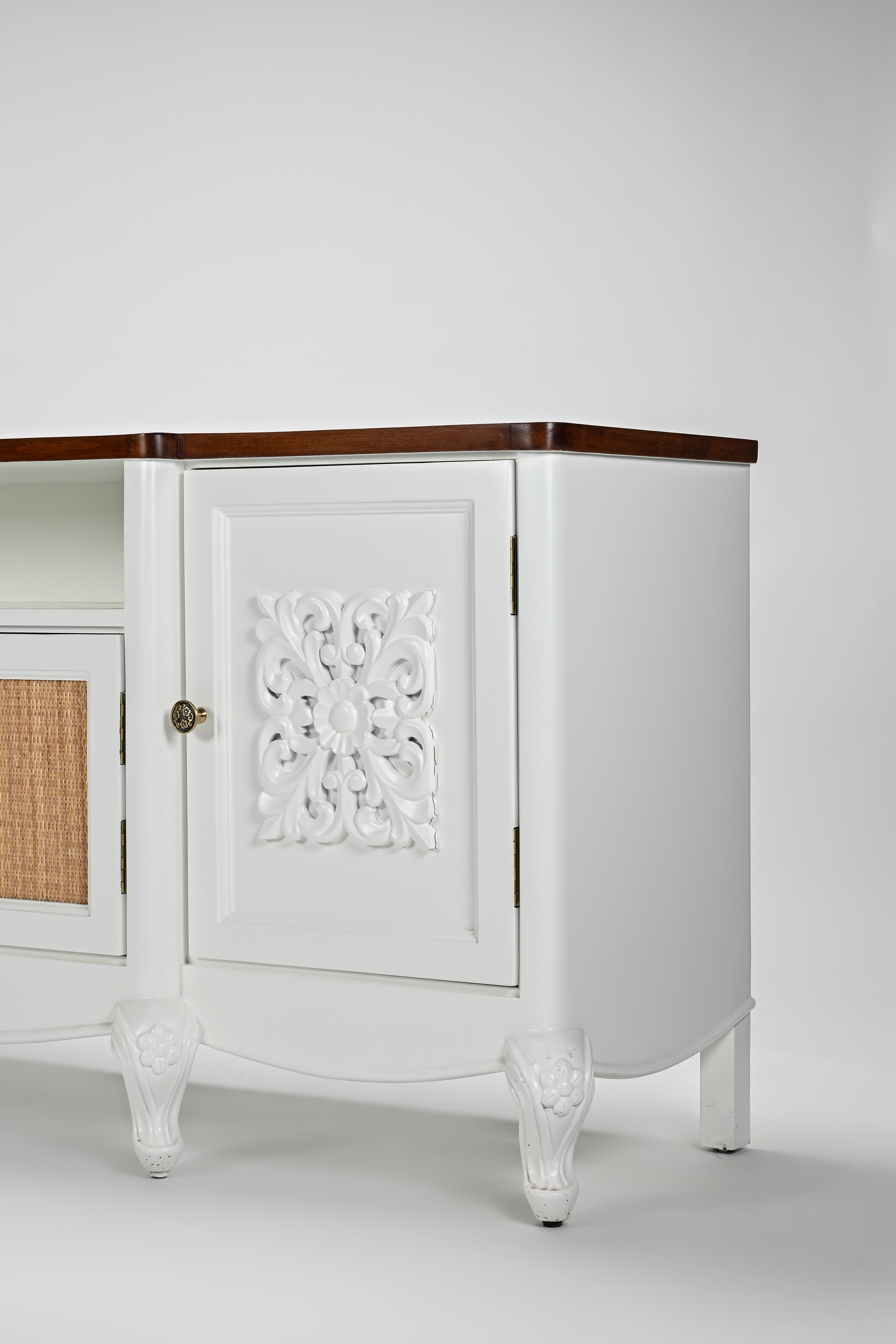 White cabinet with decorative carvings on a white background