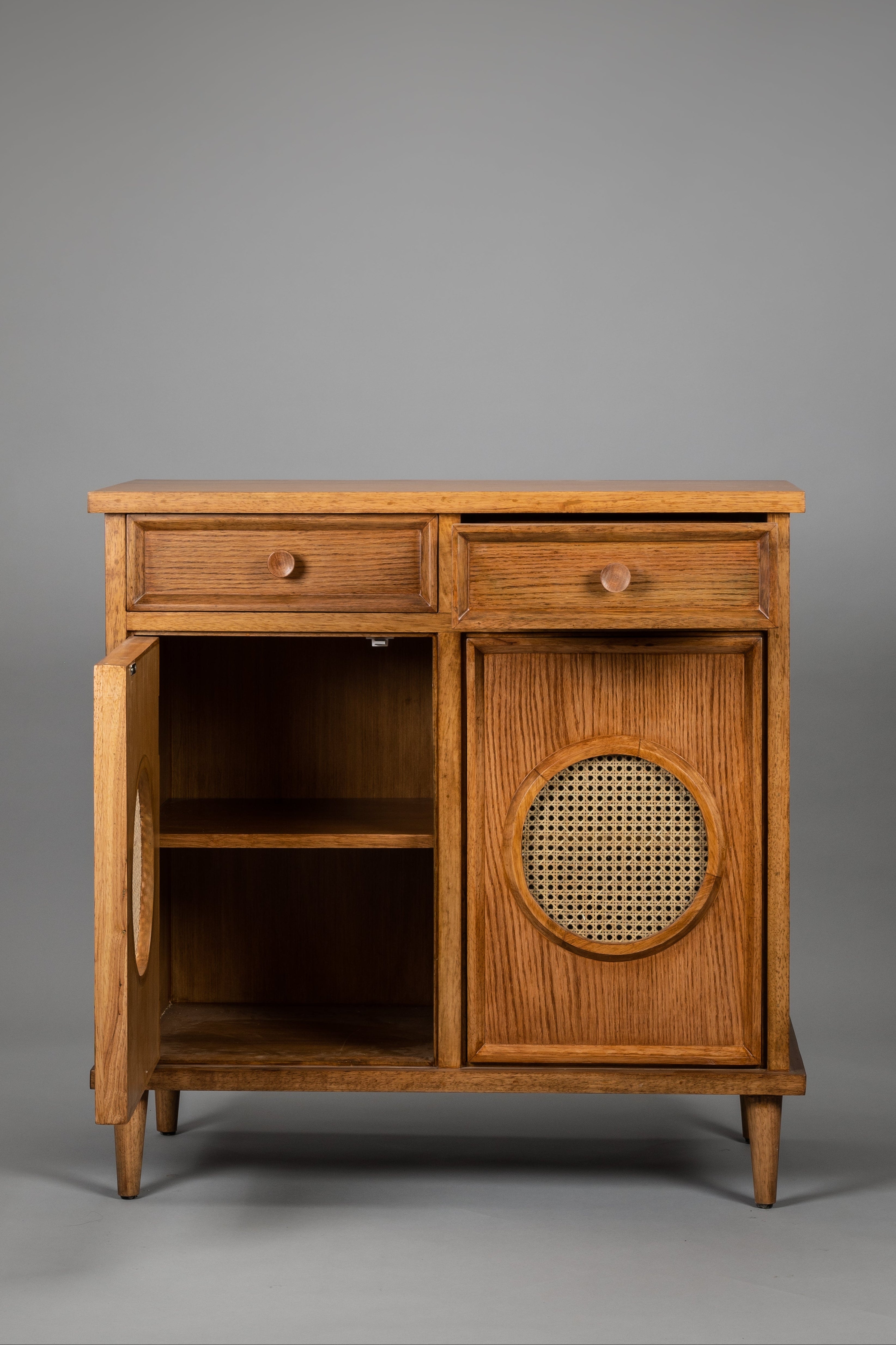 Wooden sideboard with a wicker door on a gray background