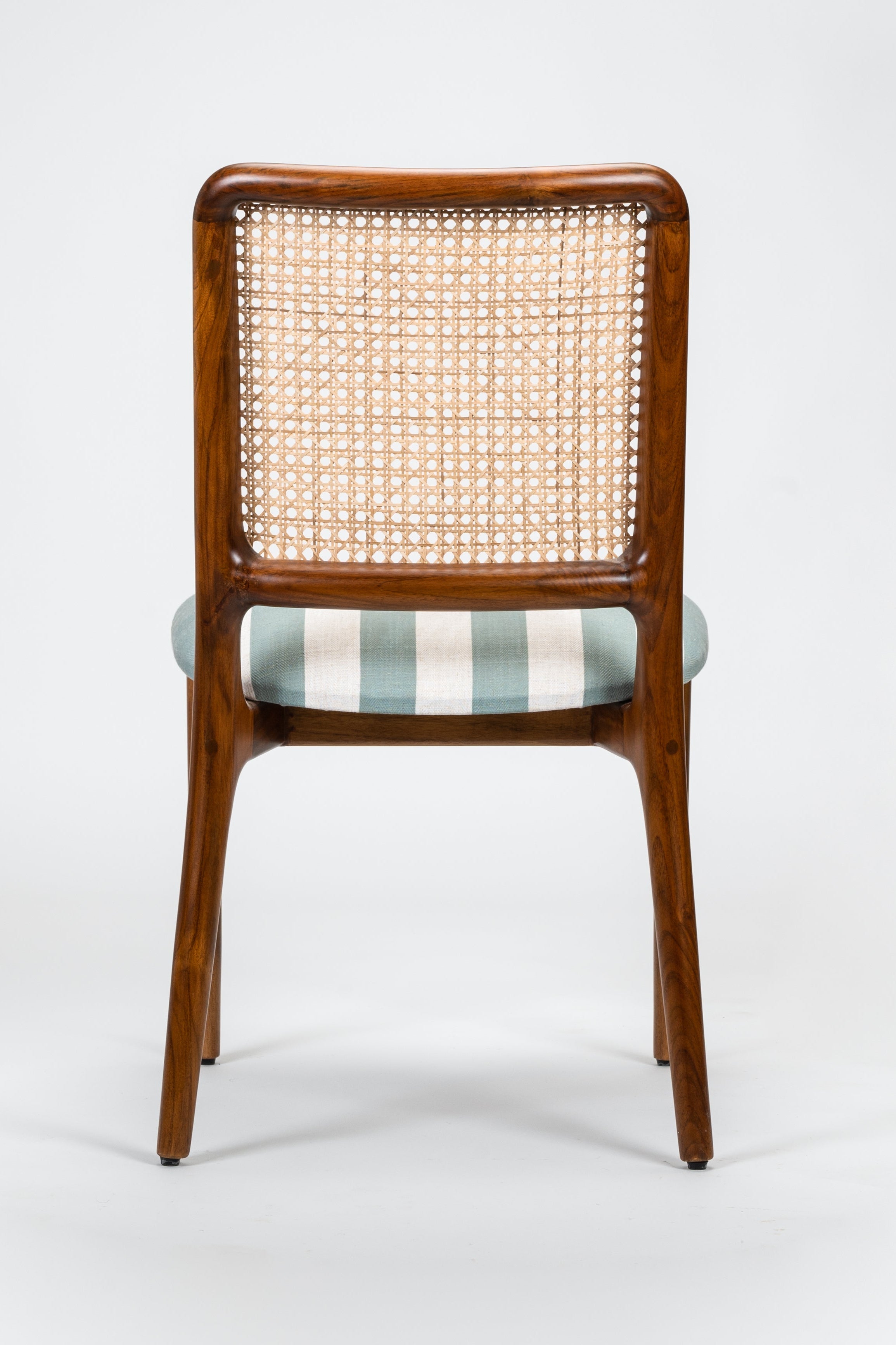 Wooden chair with wicker backrest and striped cushion on a white background