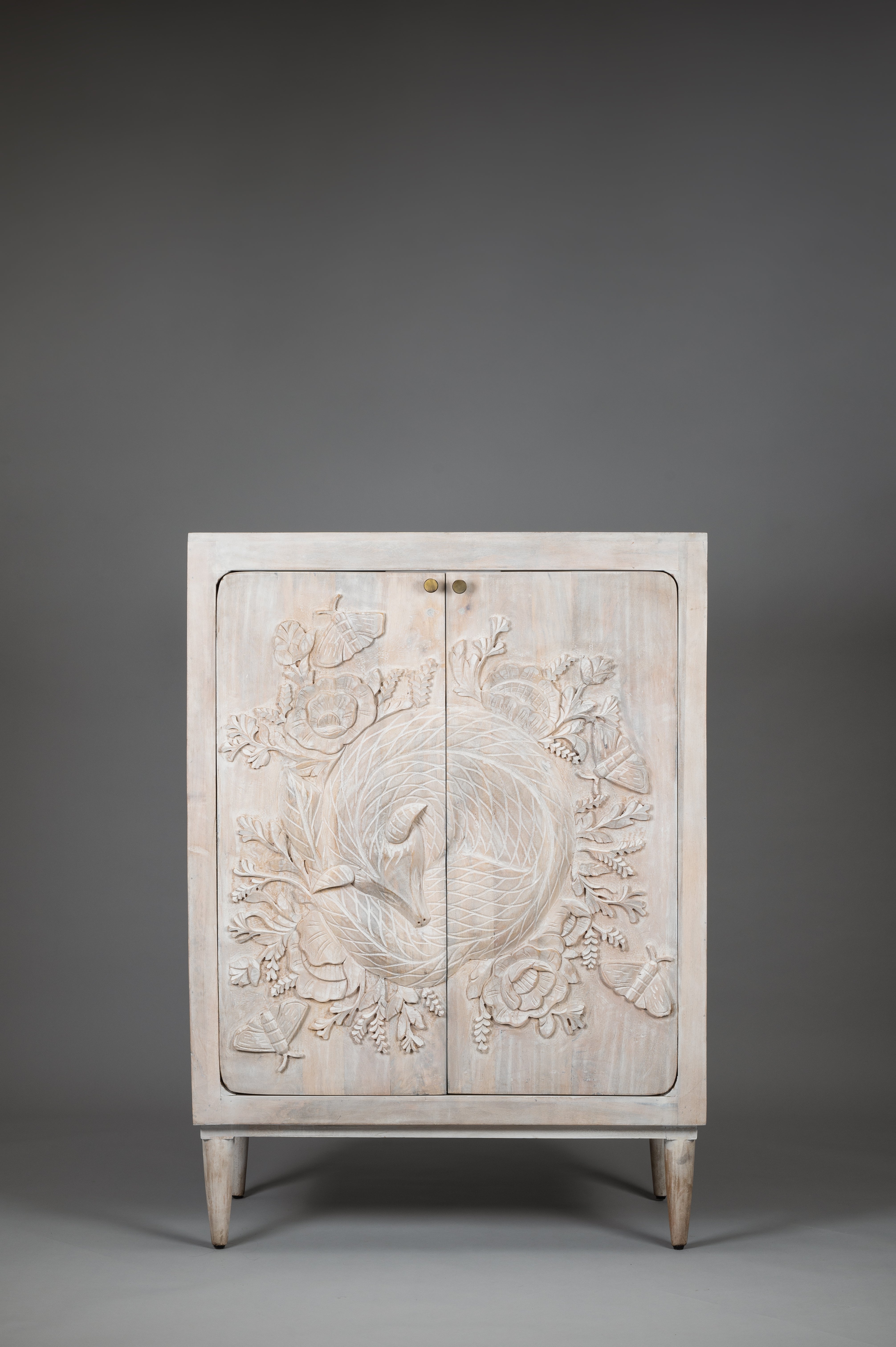 Decorative cabinet with intricate carvings on a gray background