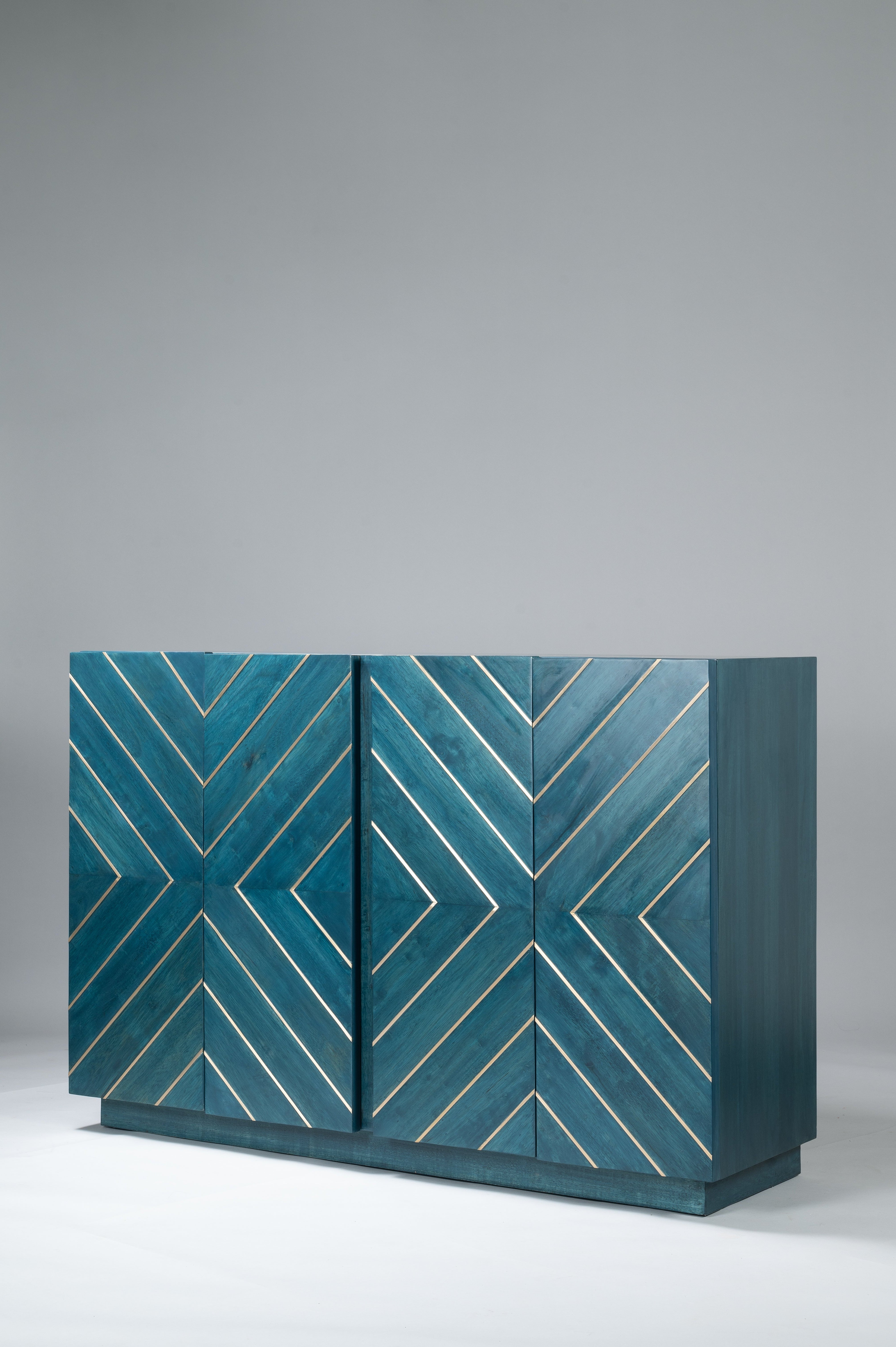 Teal cabinet with geometric pattern on a gray background
