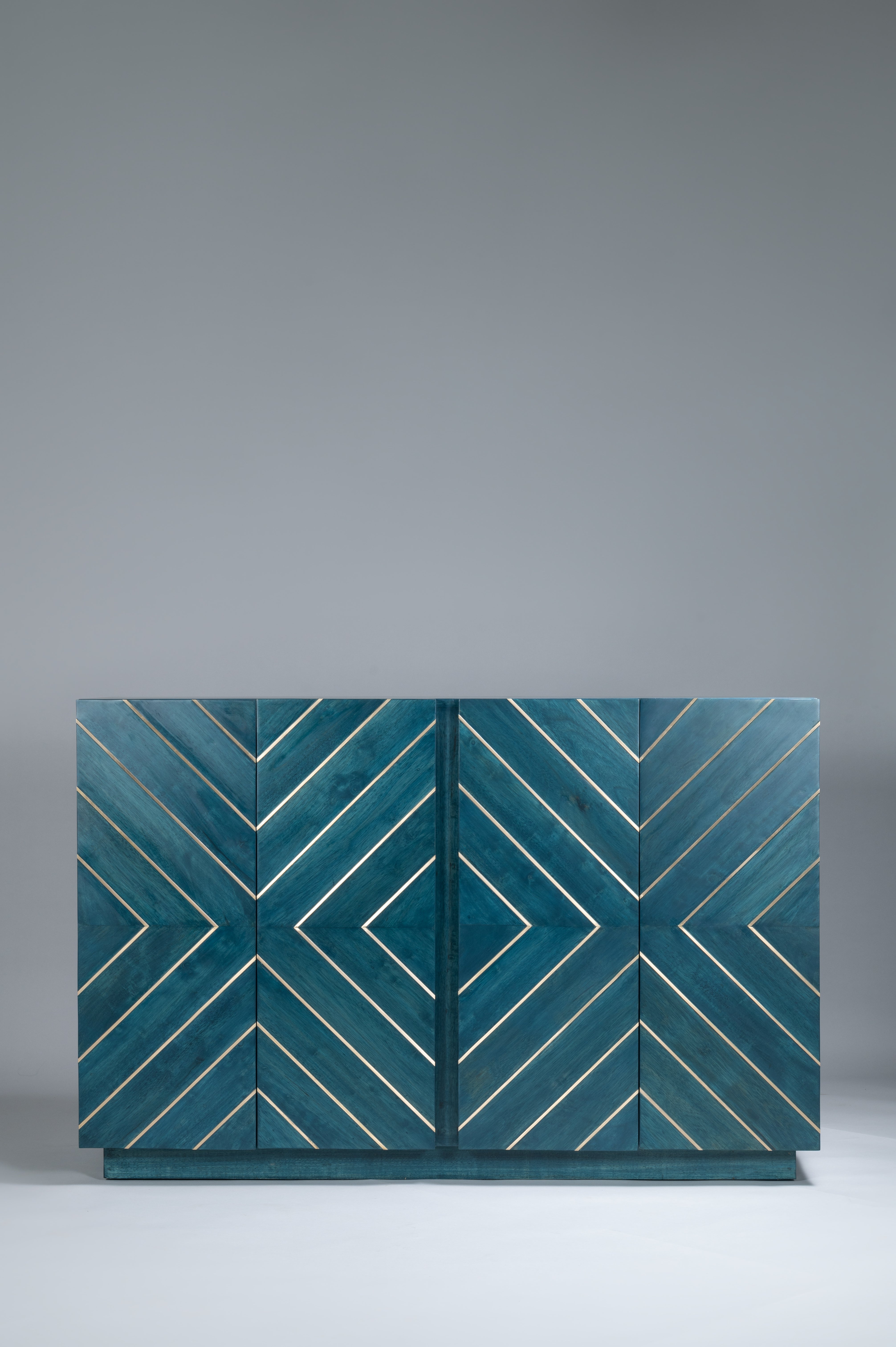 Teal cabinet with geometric pattern on a gray background