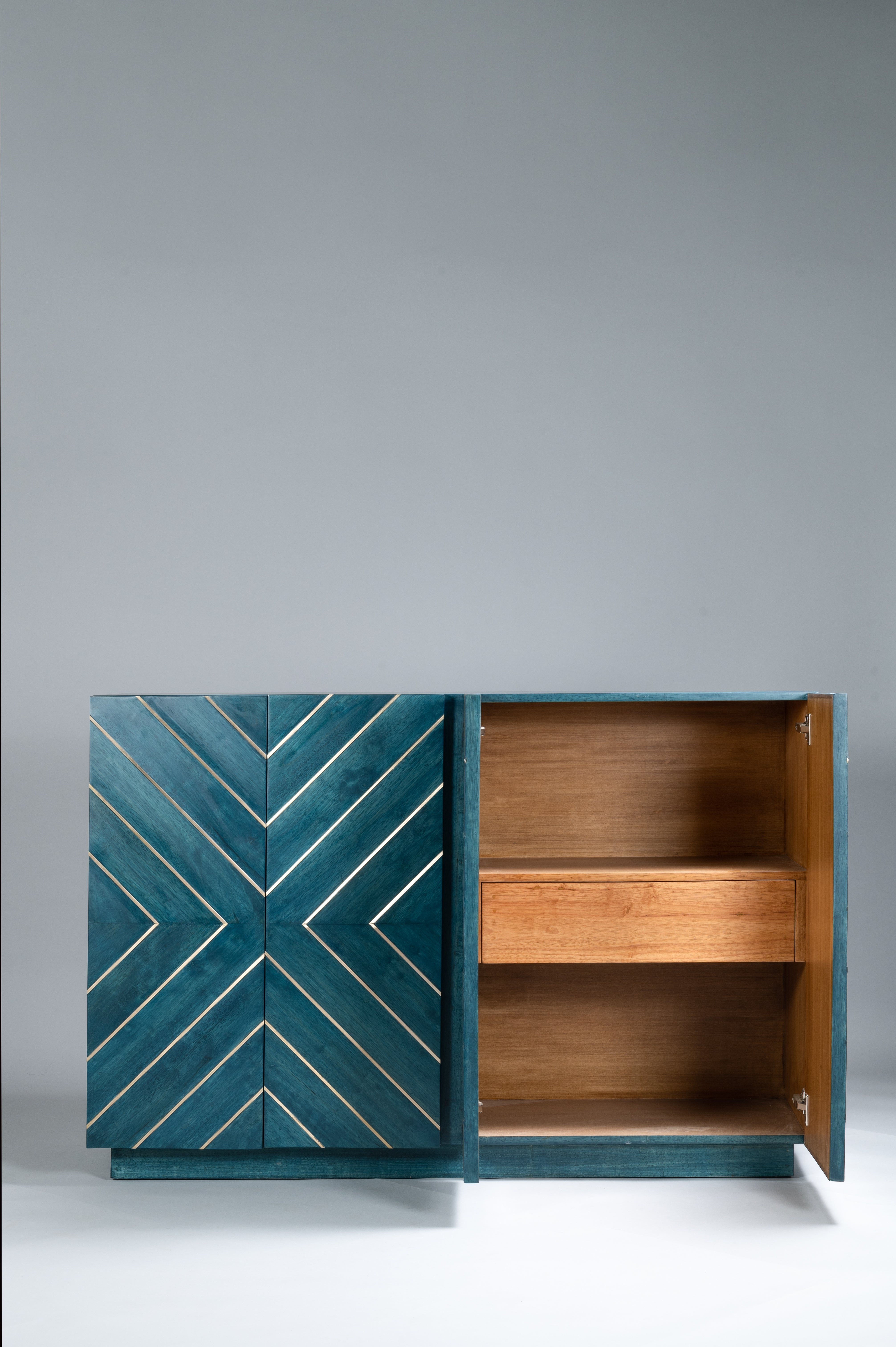 Teal cabinet with geometric pattern on a gray background