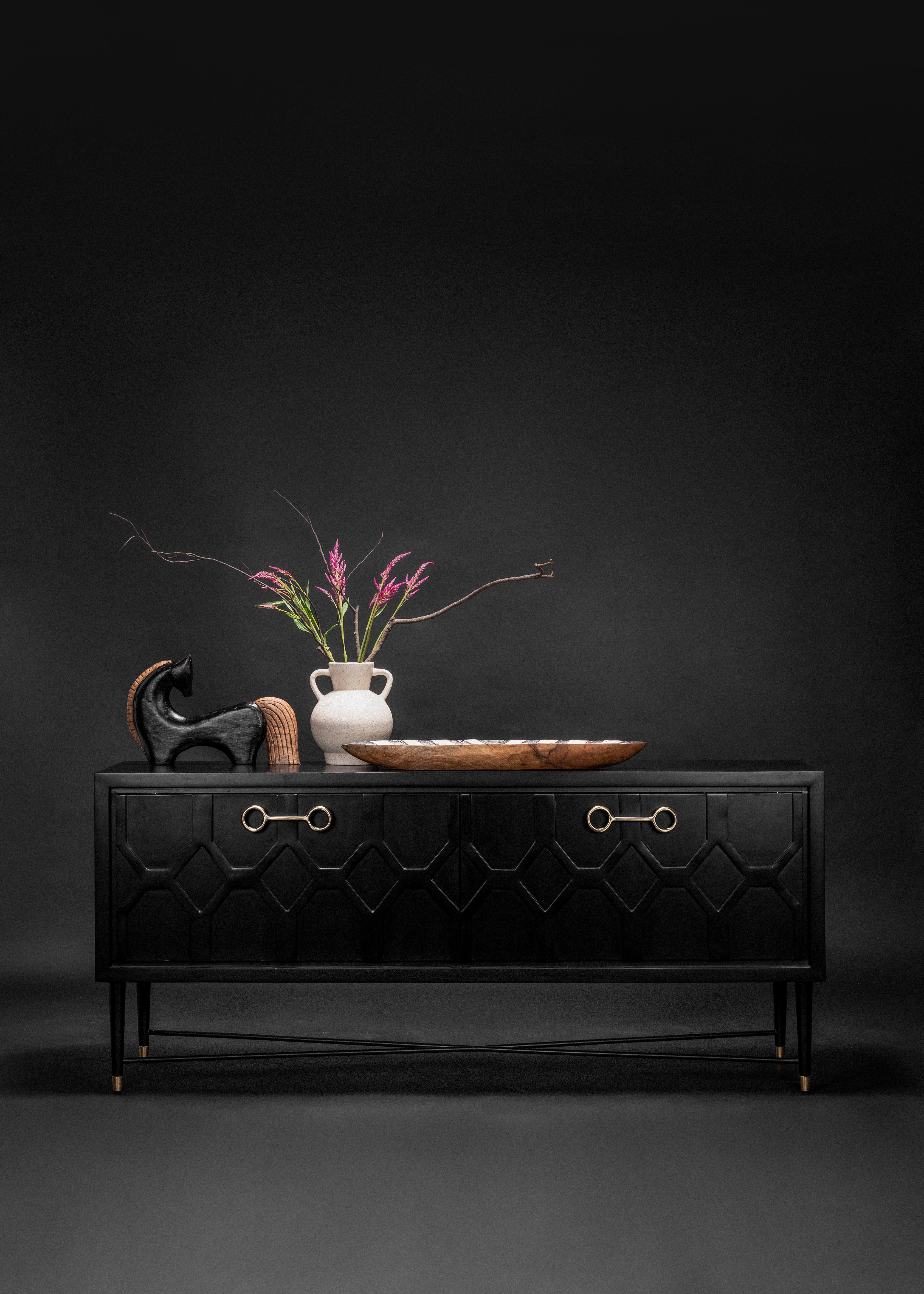 Black dresser with decorative items on a dark background