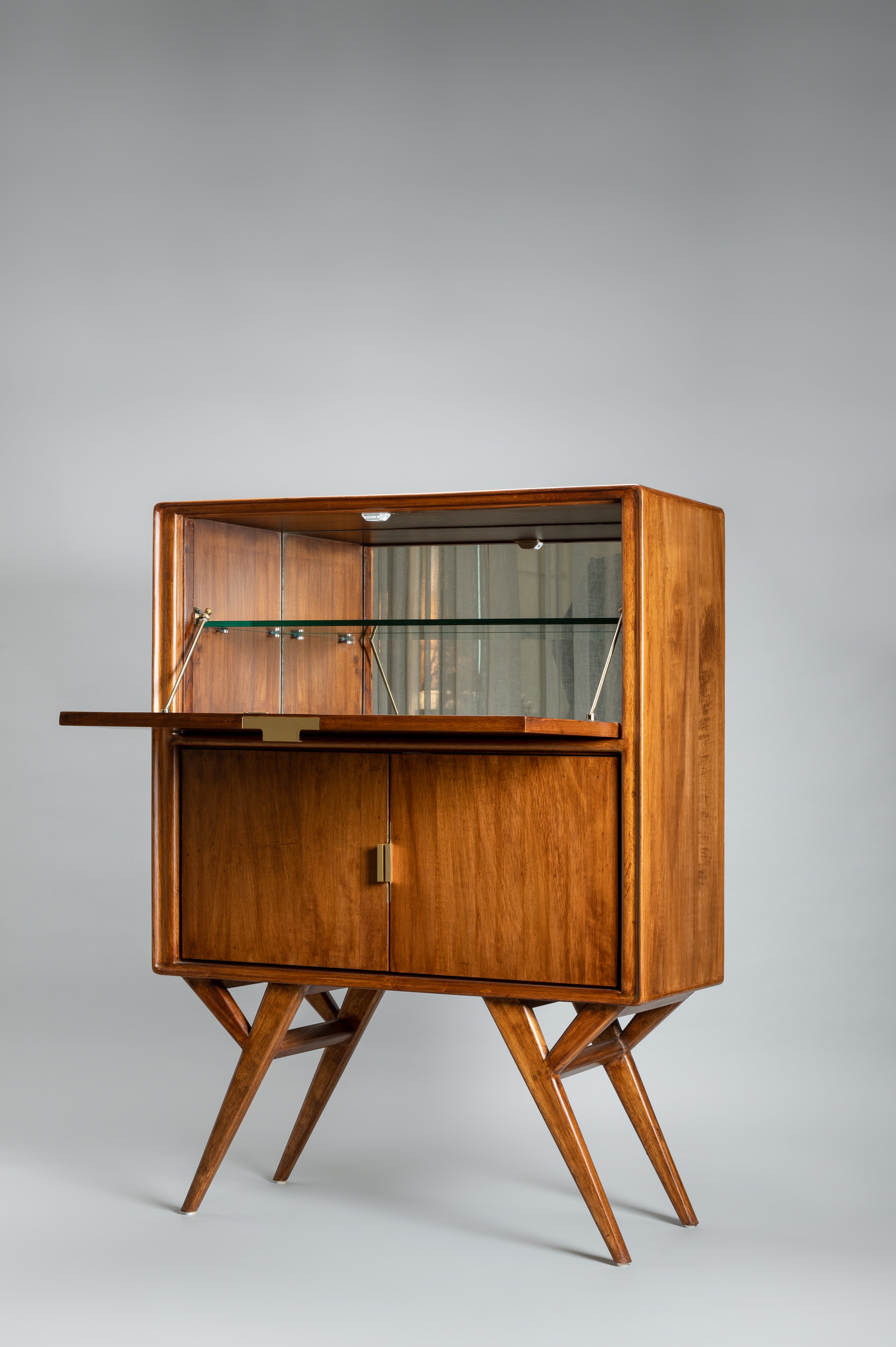 Wooden bar cabinet with glass shelves on a gray background