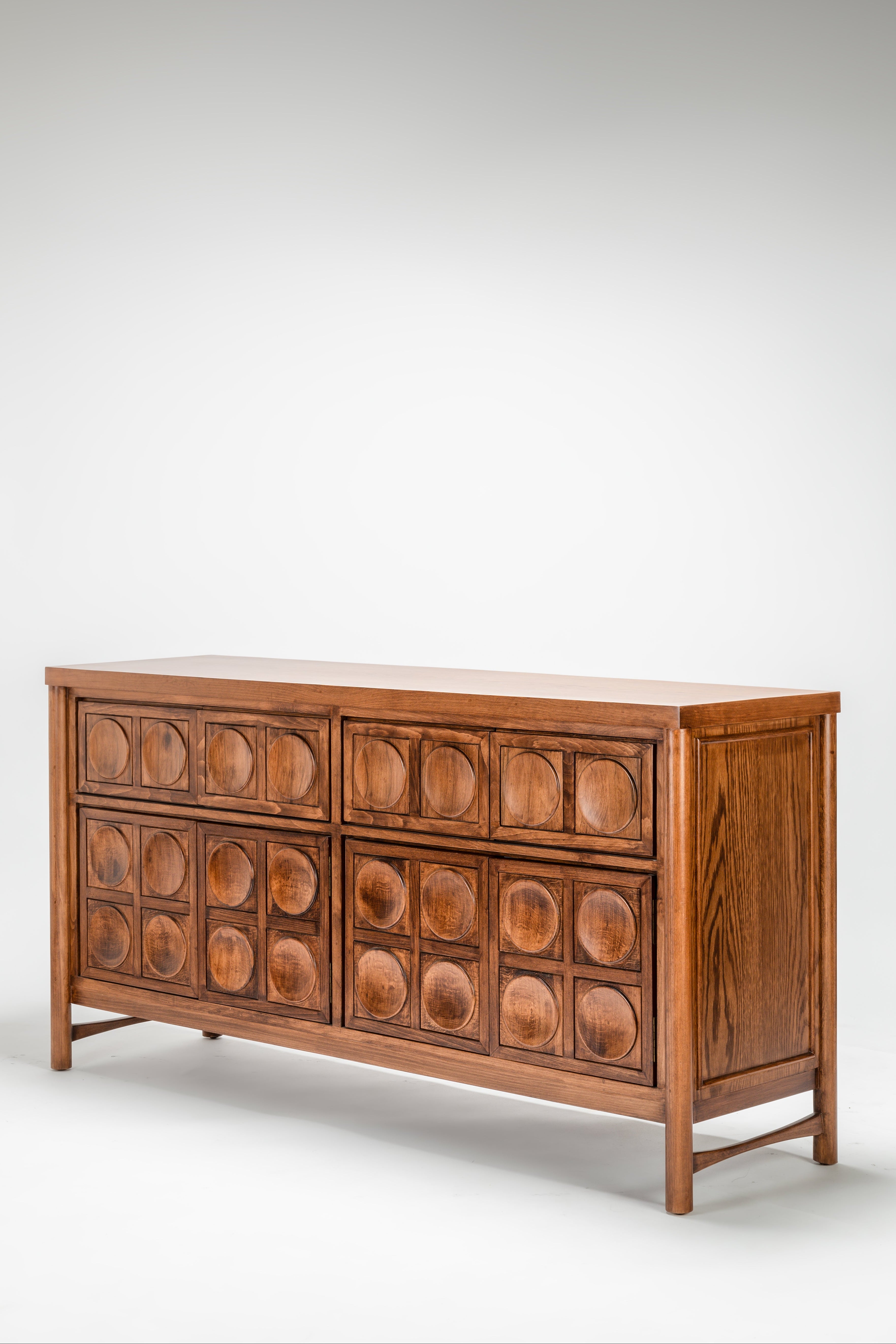 Wooden dresser with circular patterns on a white background