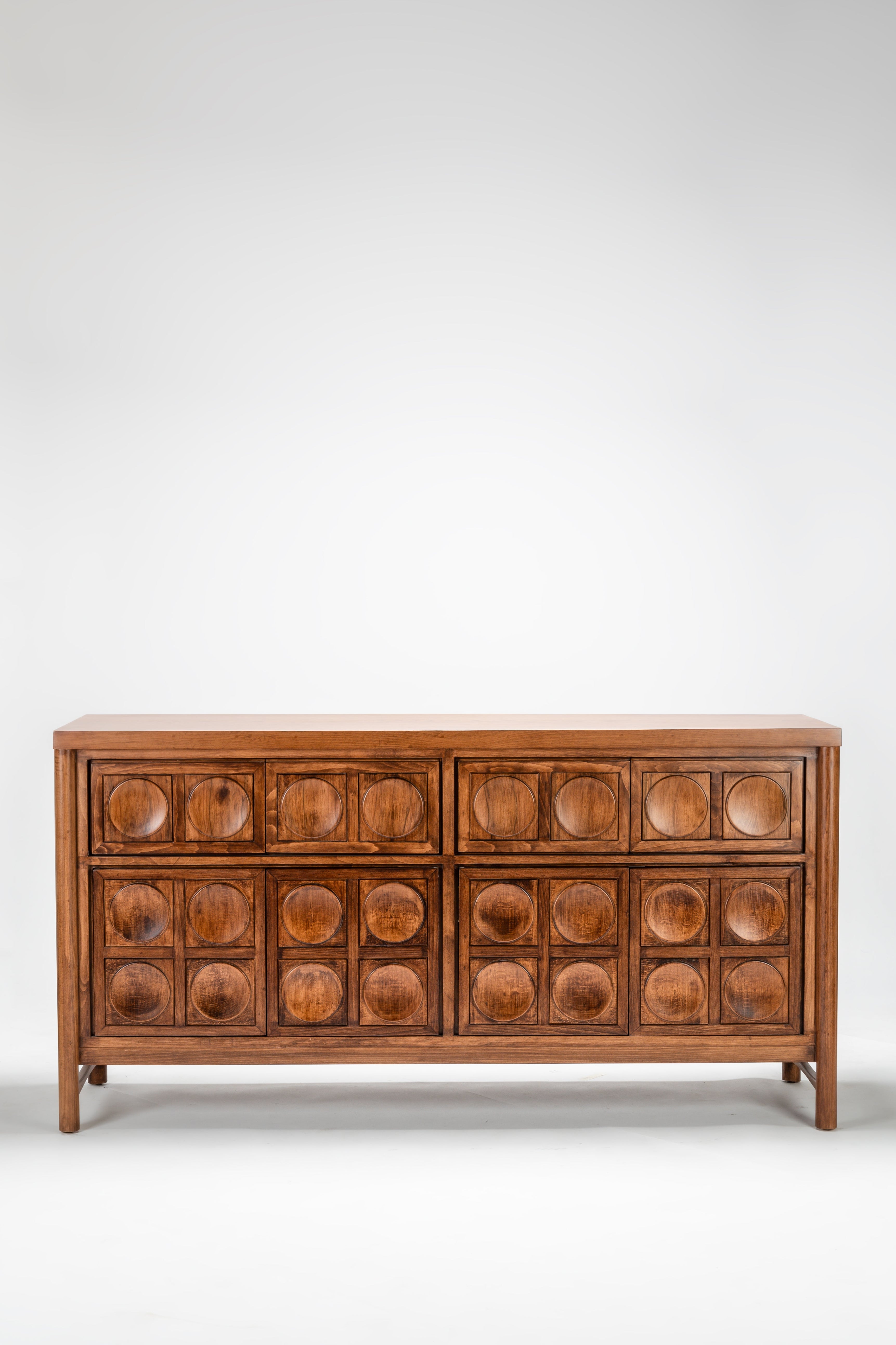 Wooden dresser with circular patterns on a white background