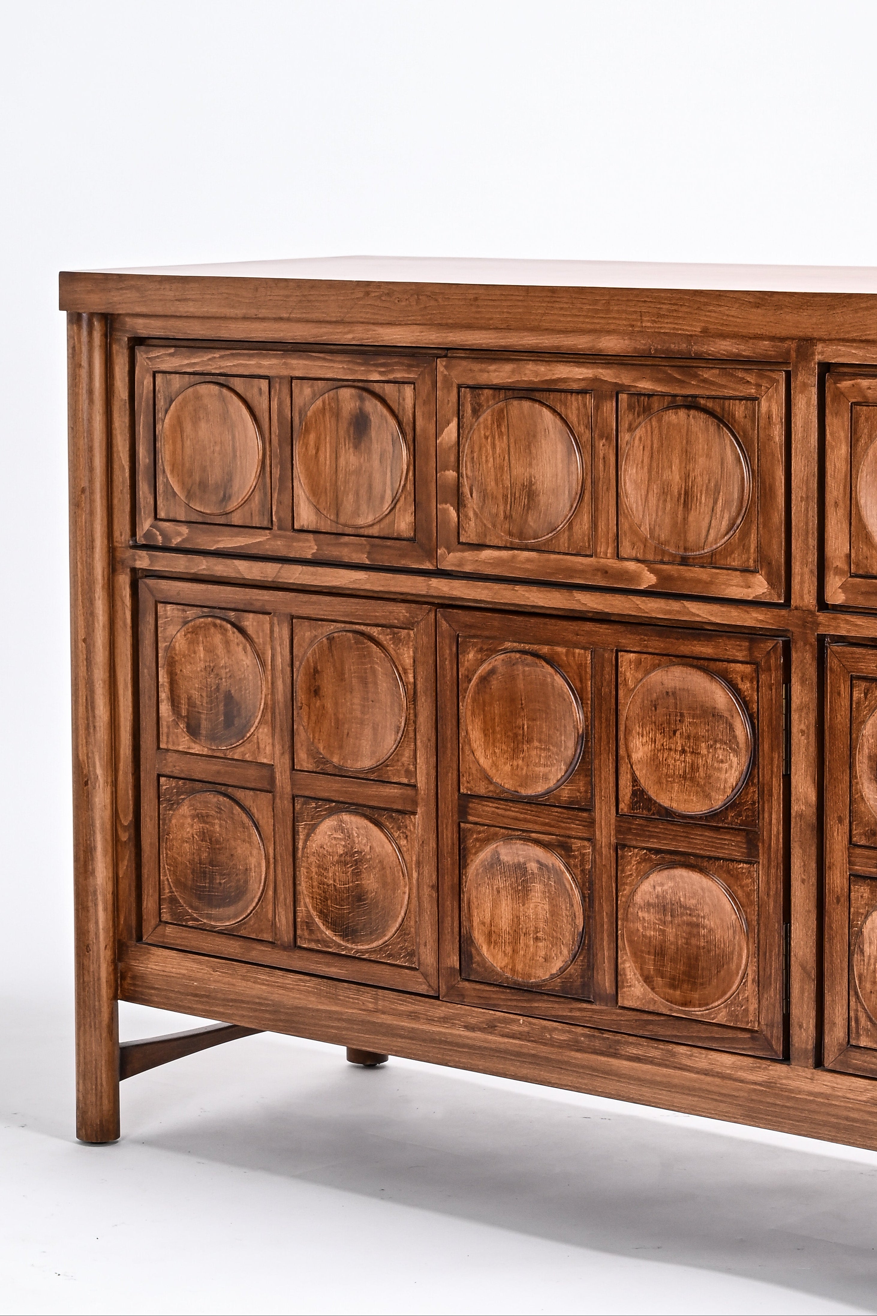 Wooden dresser with circular patterns on a white background