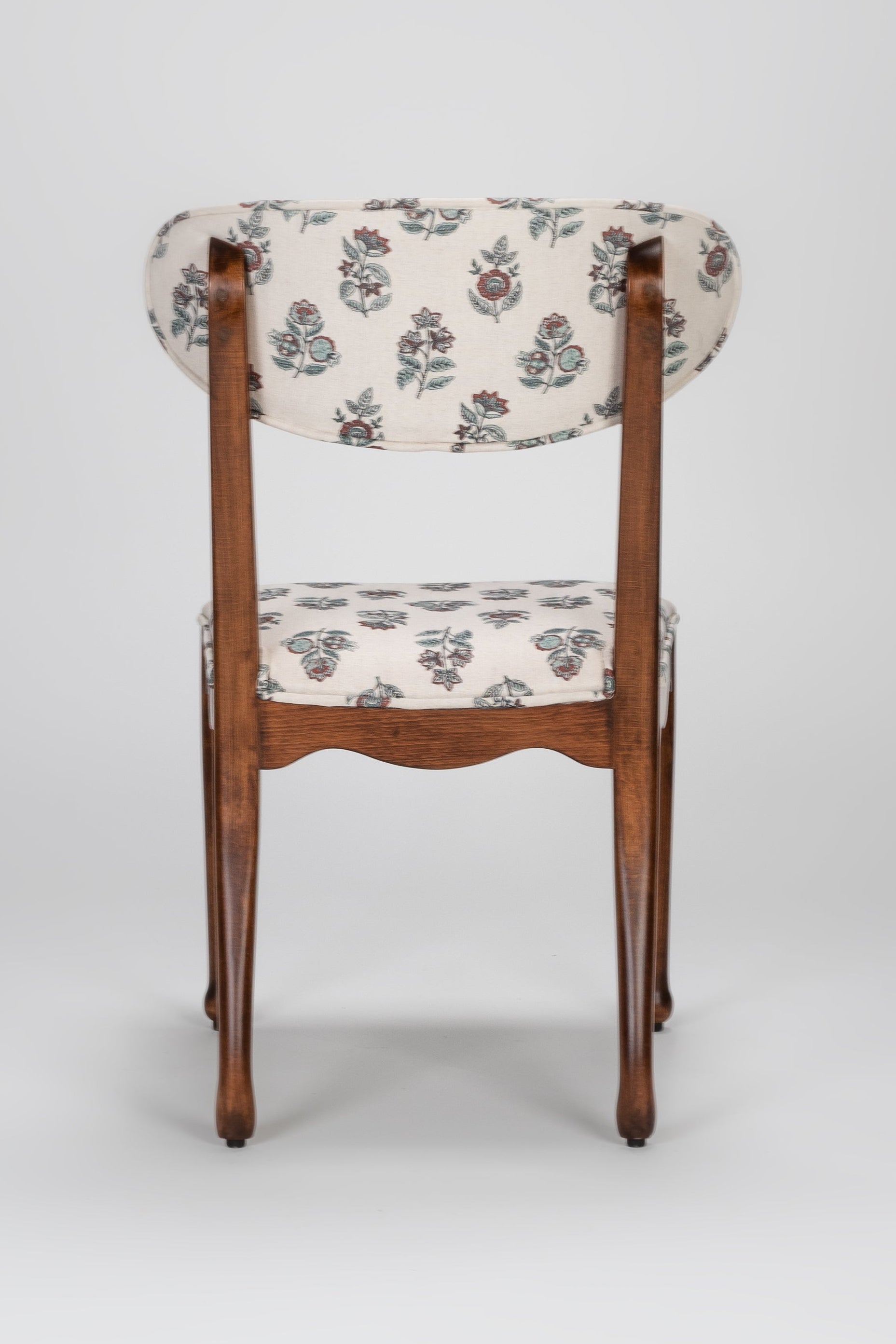 Chair with floral patterned cushion on a gray background