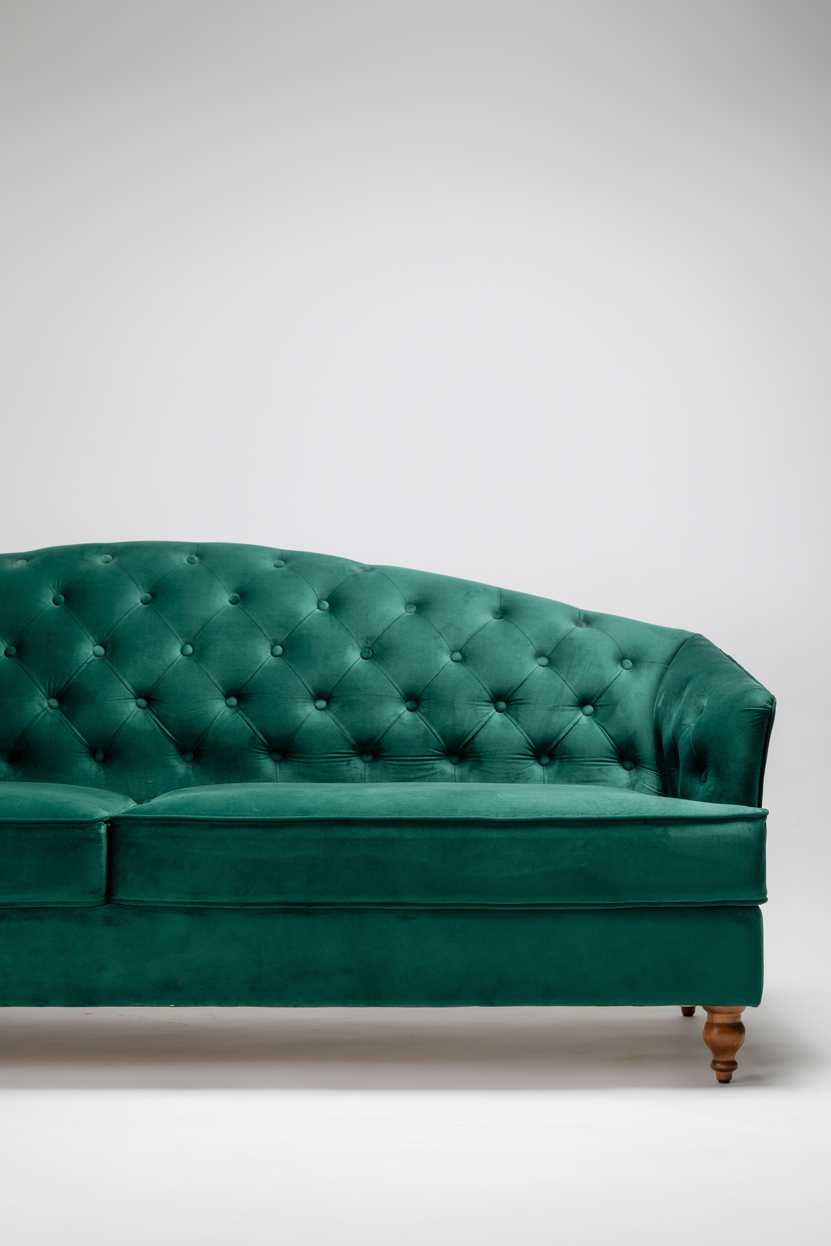 Green velvet sofa on a white background