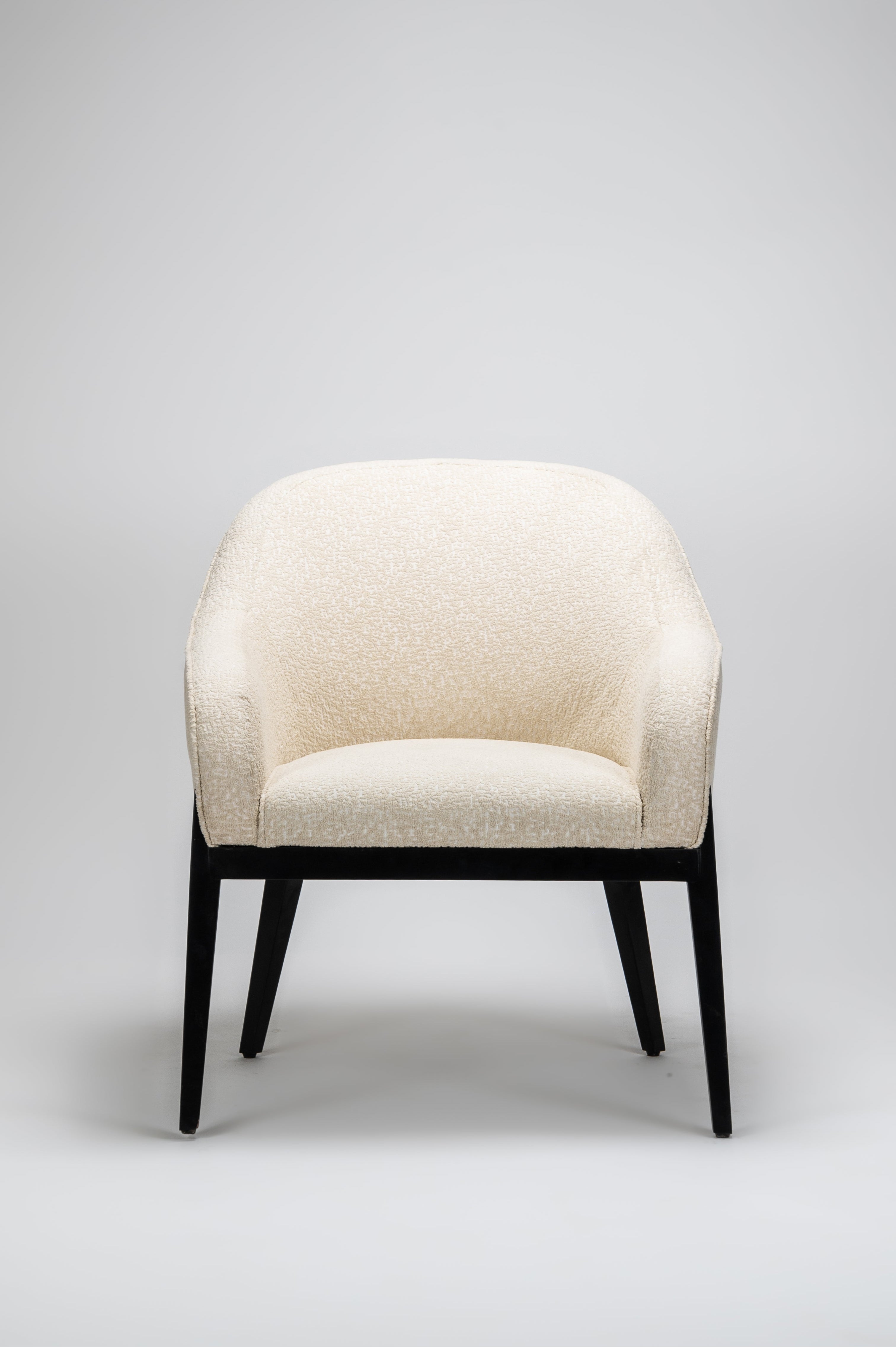 Beige armchair with black legs on a light gray background