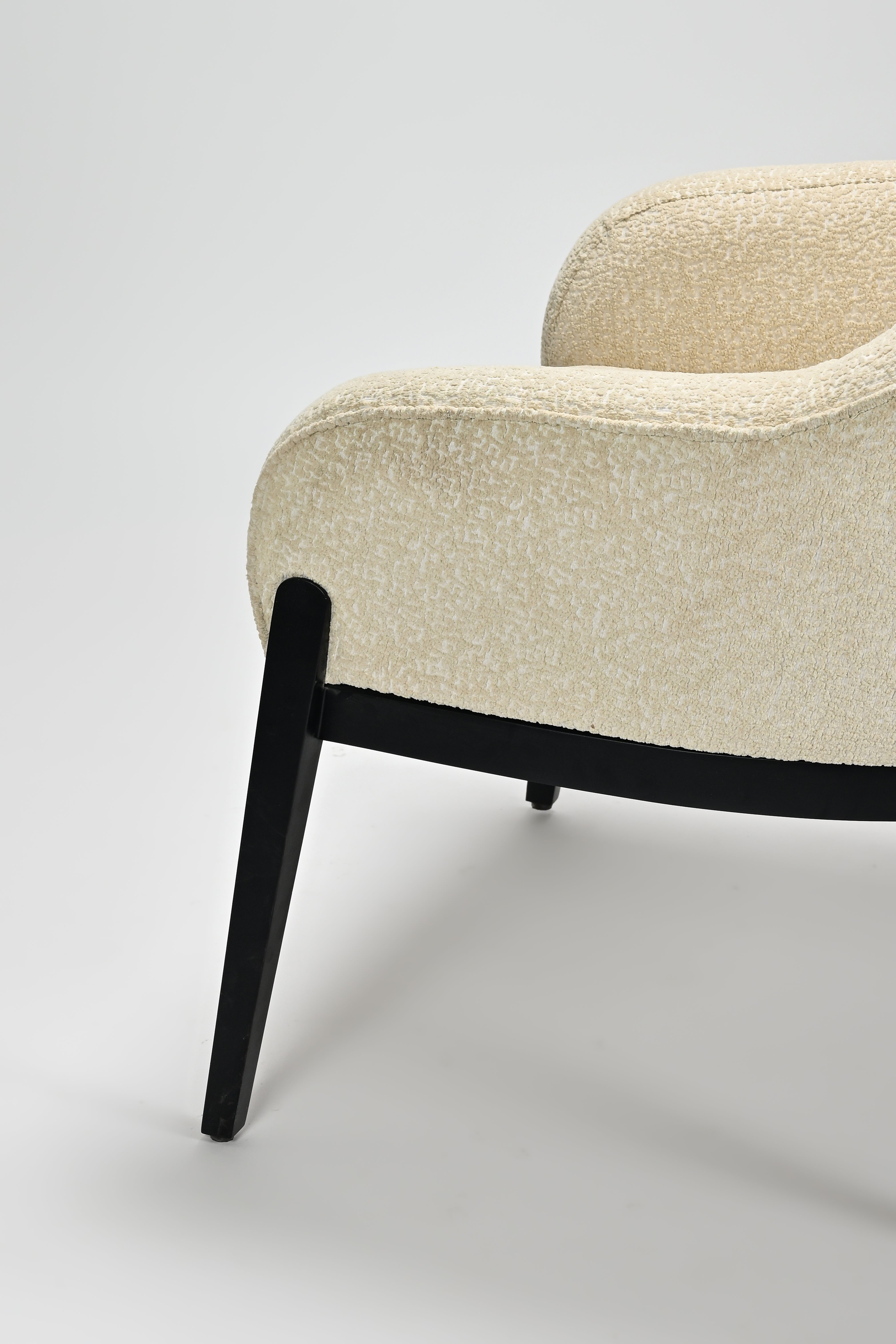 Beige armchair with black legs on a light gray background