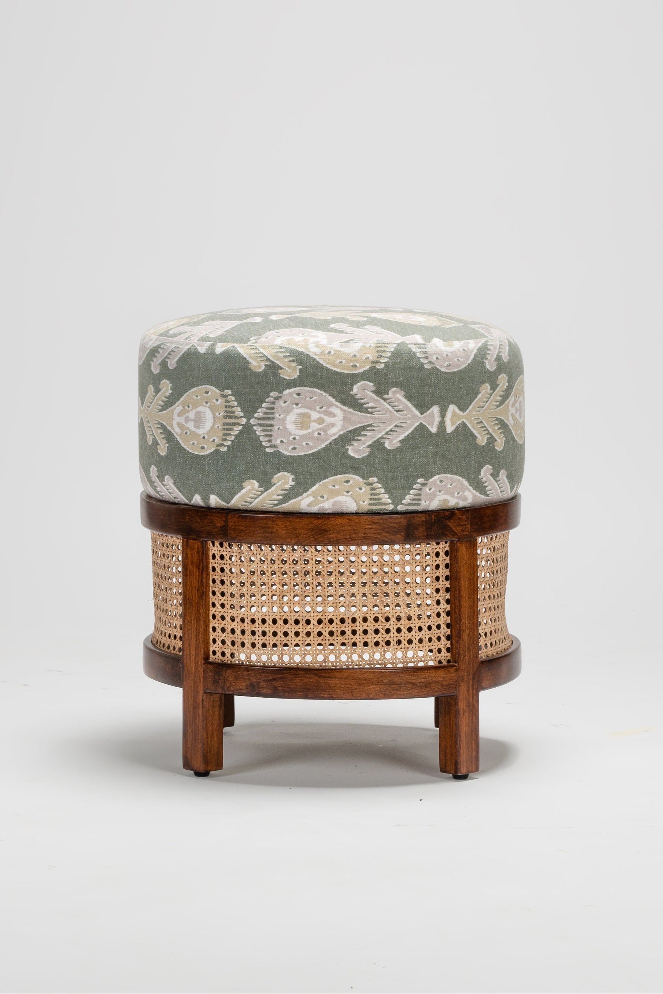 Small ottoman with floral cushion and wicker base on a white background