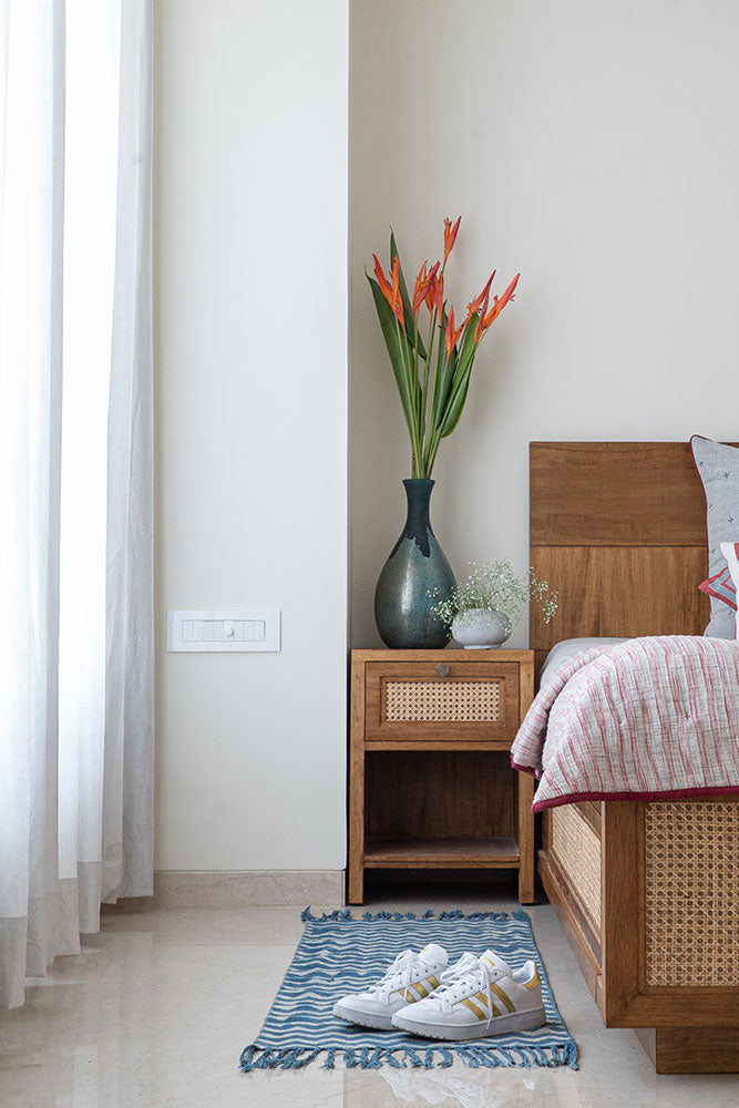 Bedroom with wooden bed, nightstand, and decorative pillows.