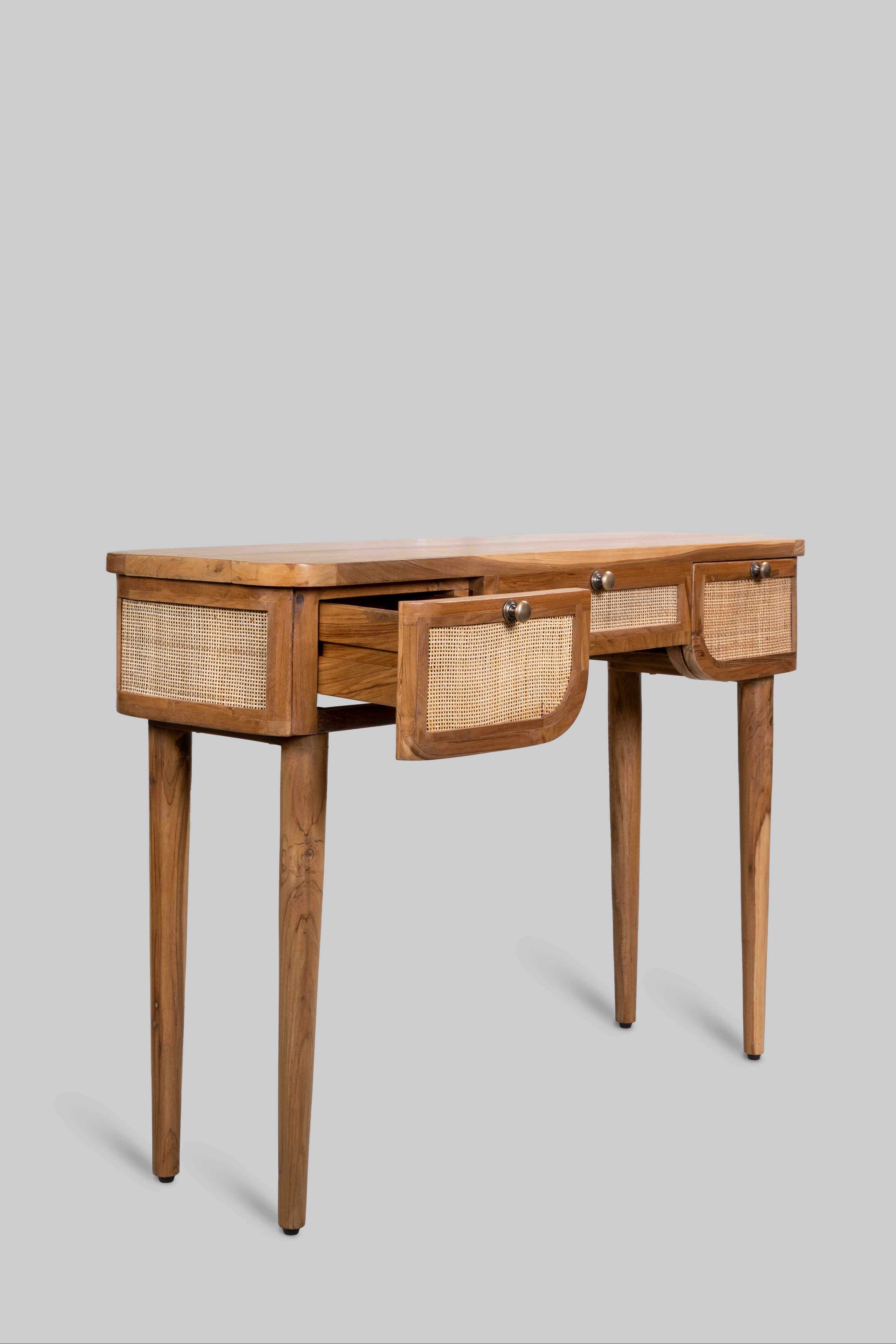 Wooden desk with wicker drawers on a gray background