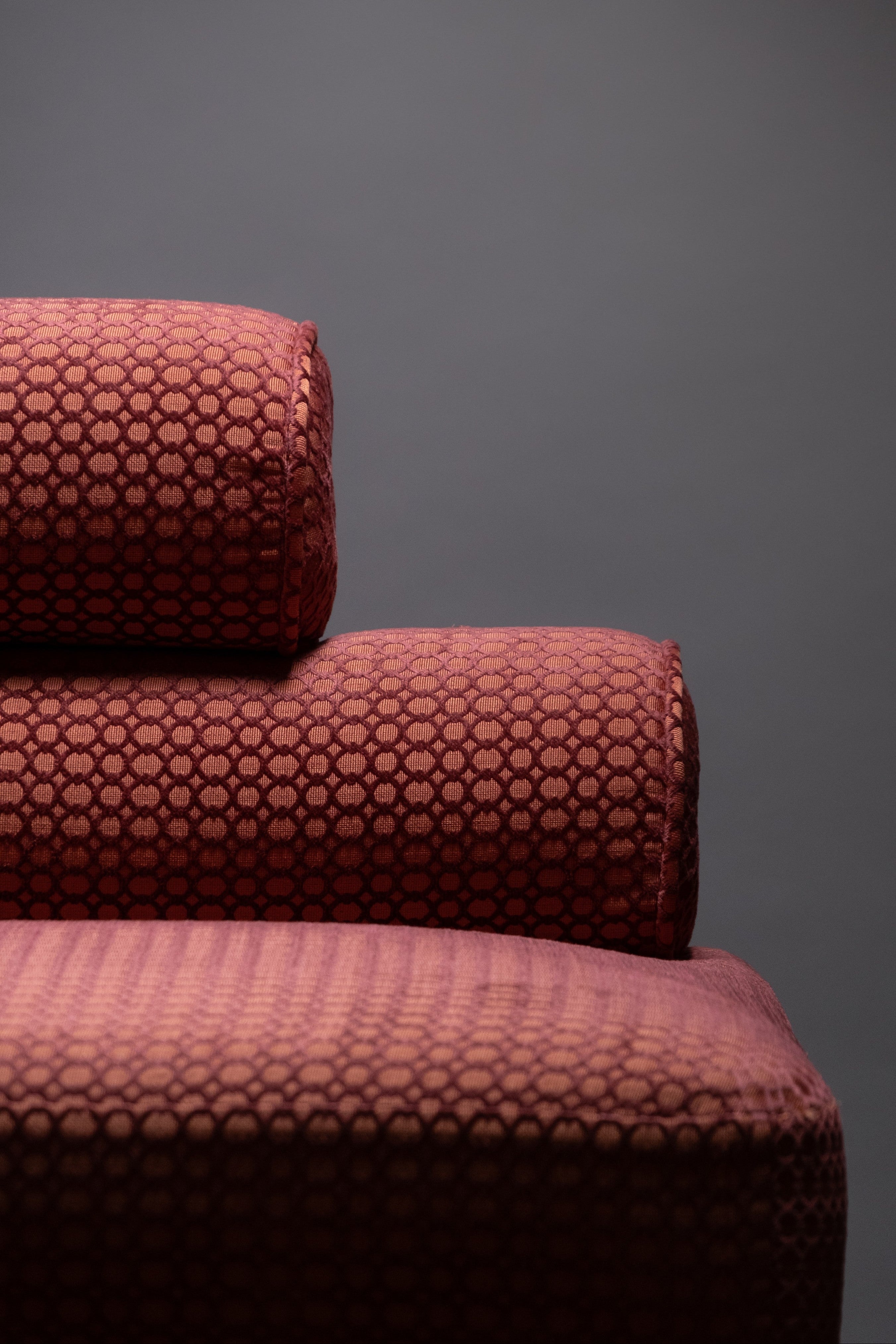 Maroon textured sofa against a gray background