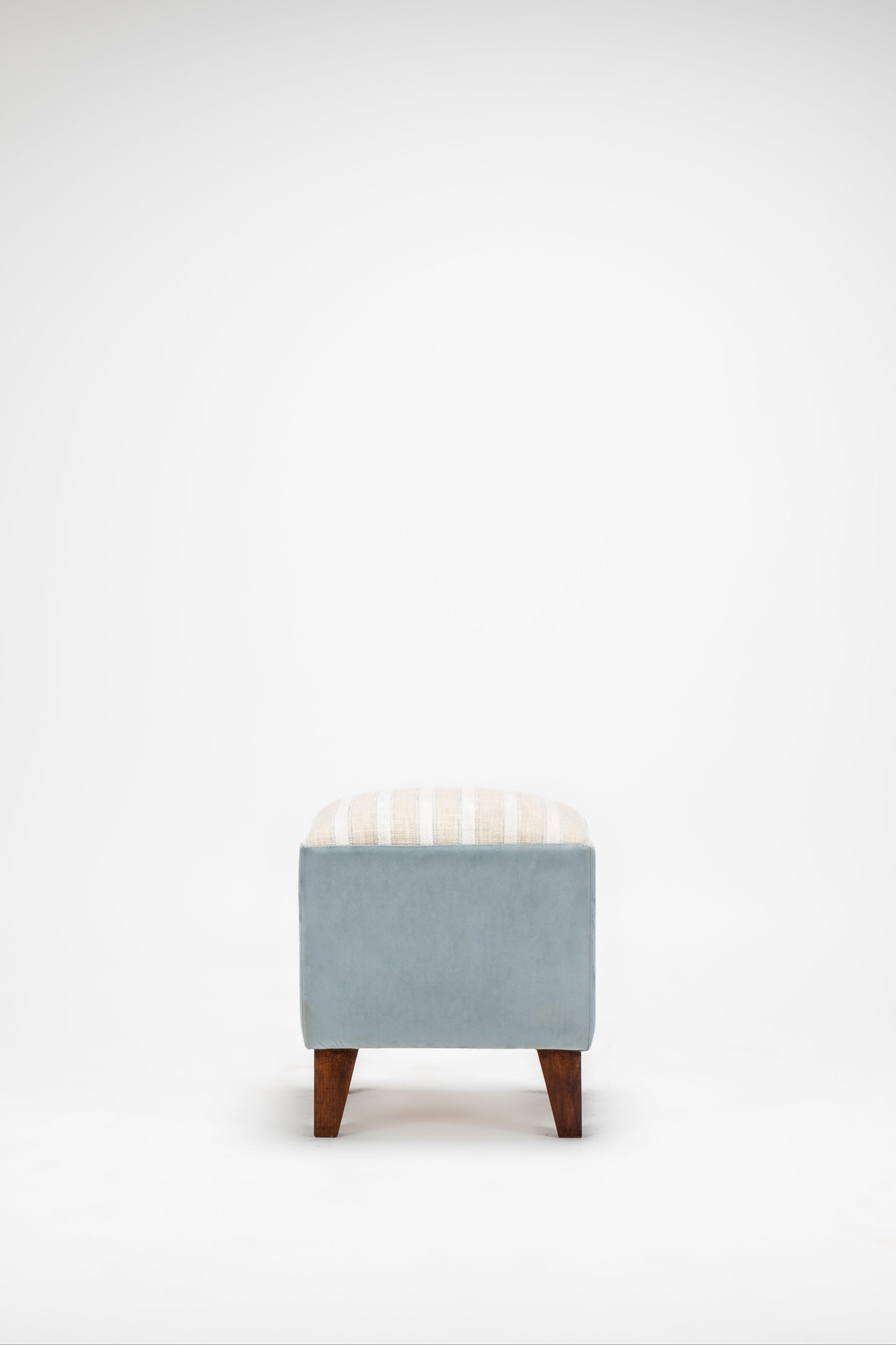 Small light blue stool with wooden legs on a white background