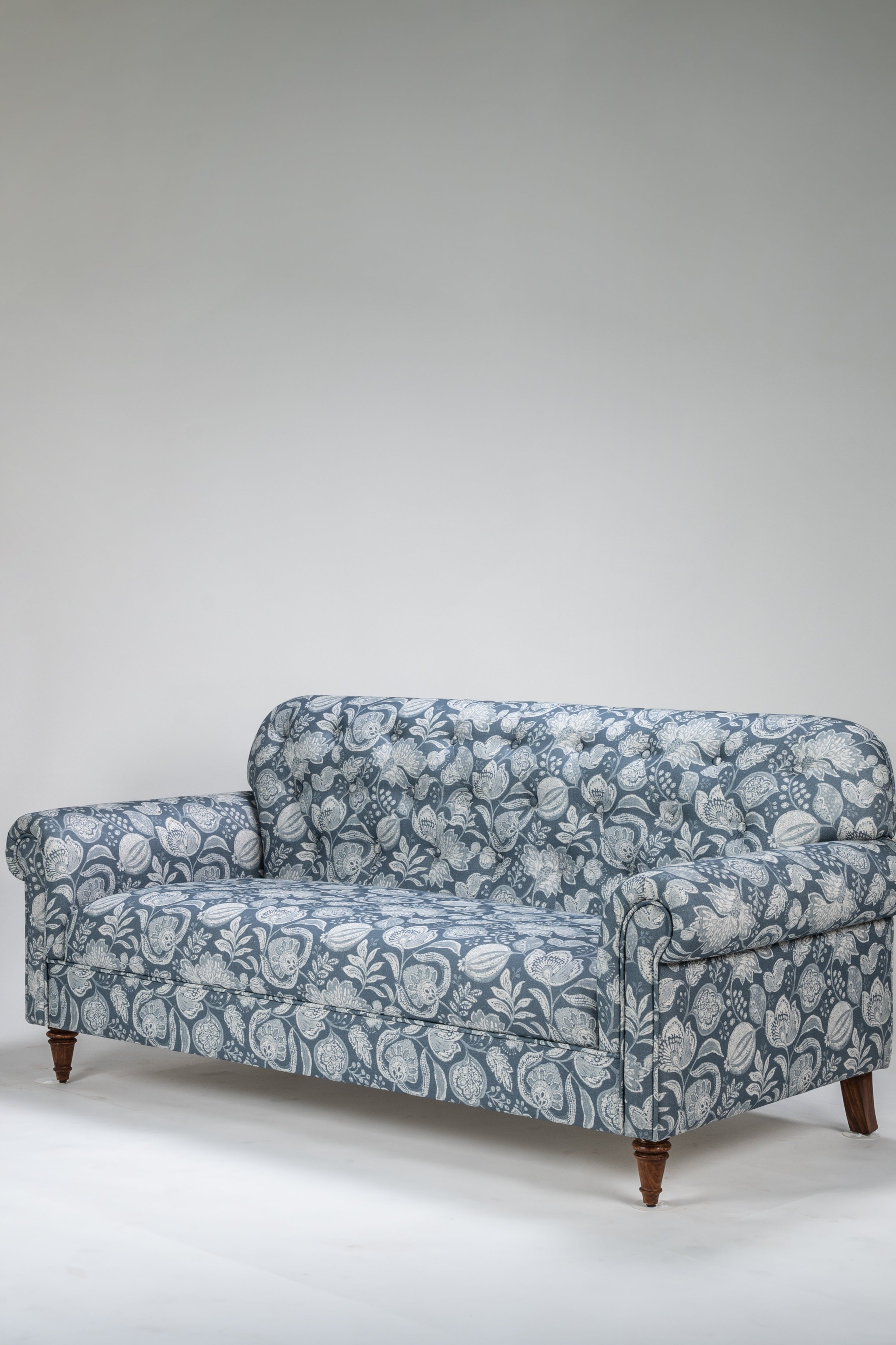 Blue floral-patterned sofa on a white background