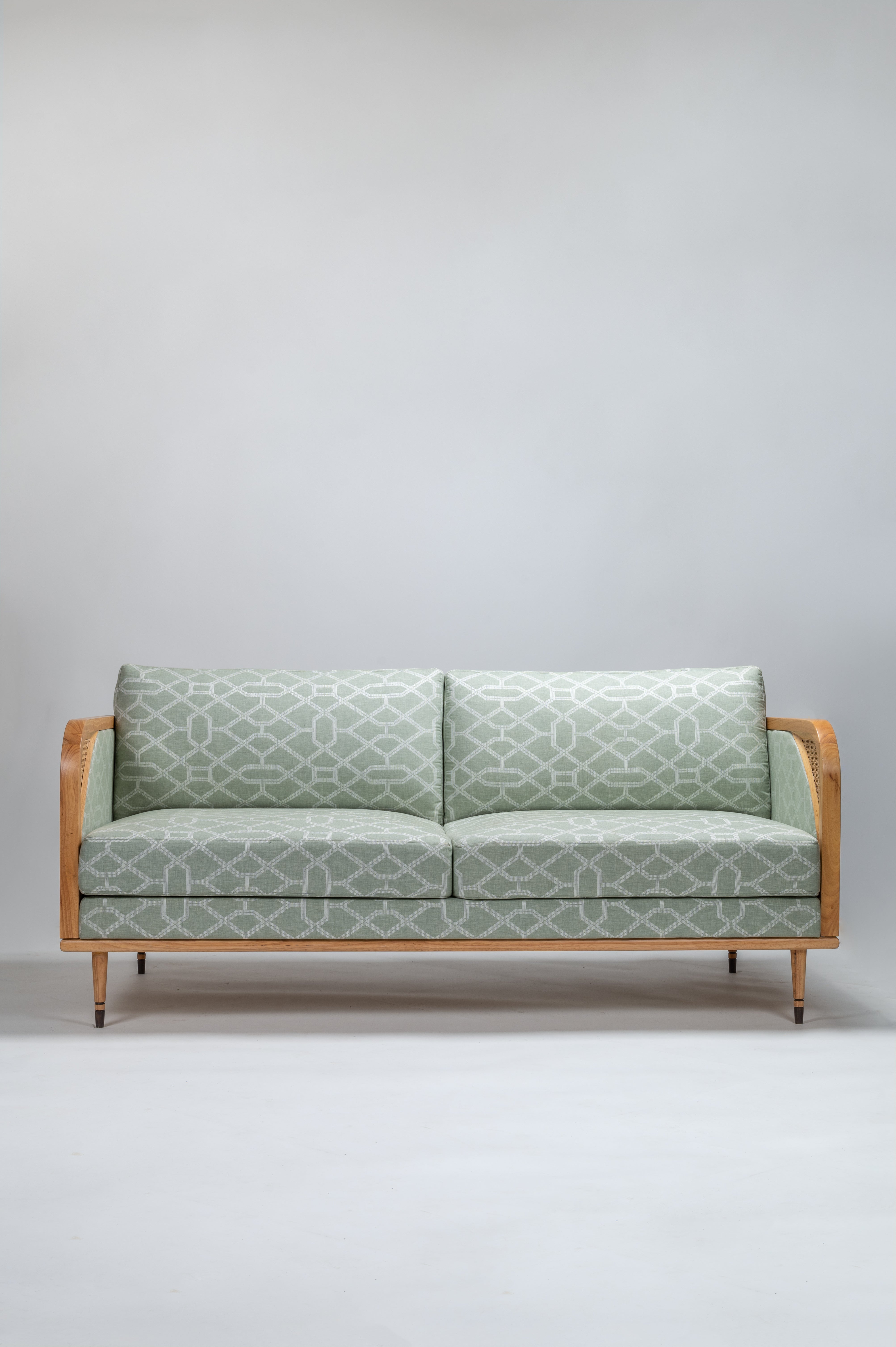 Sofa with green patterned fabric on a plain background