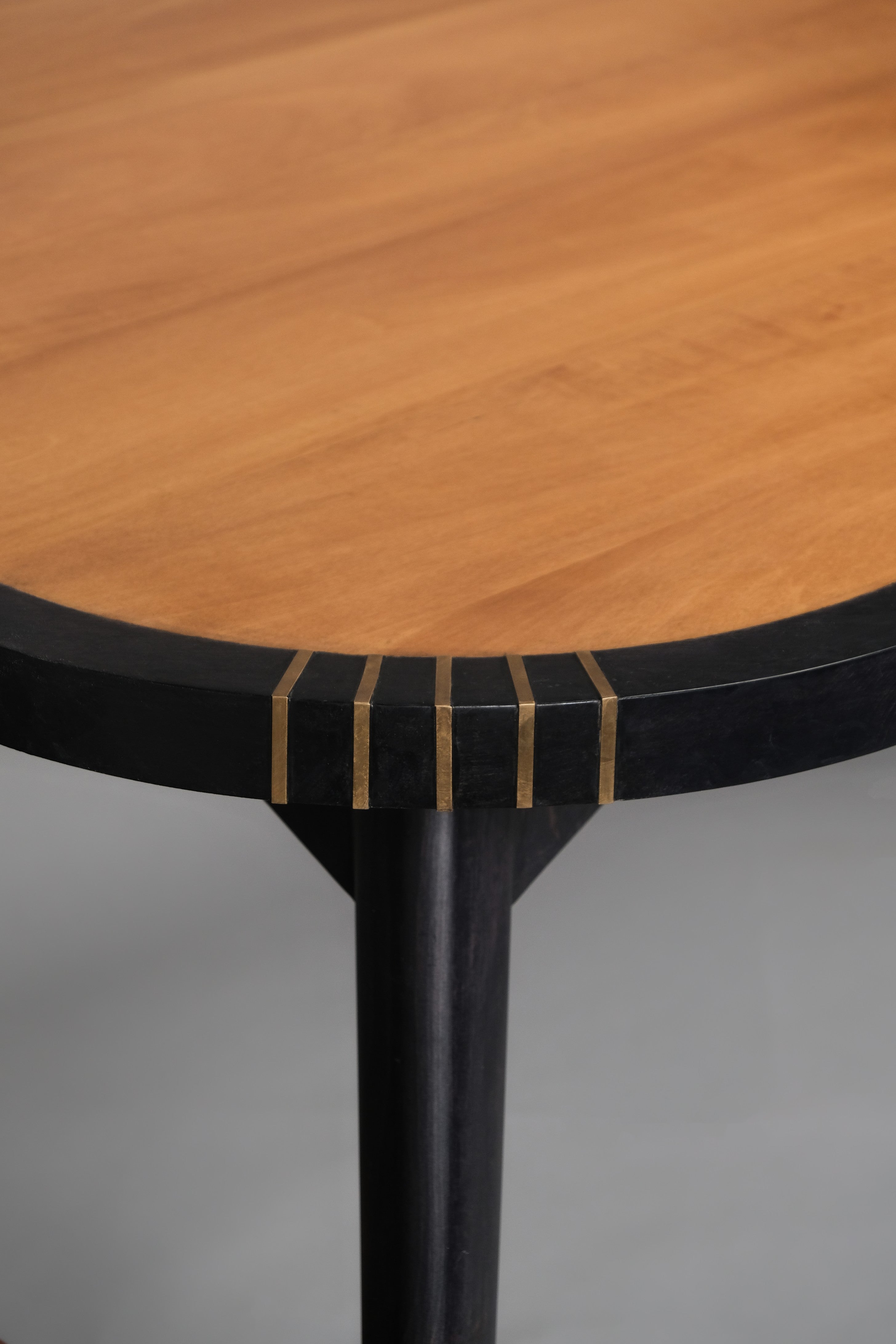 Wooden table with black base on a gray background