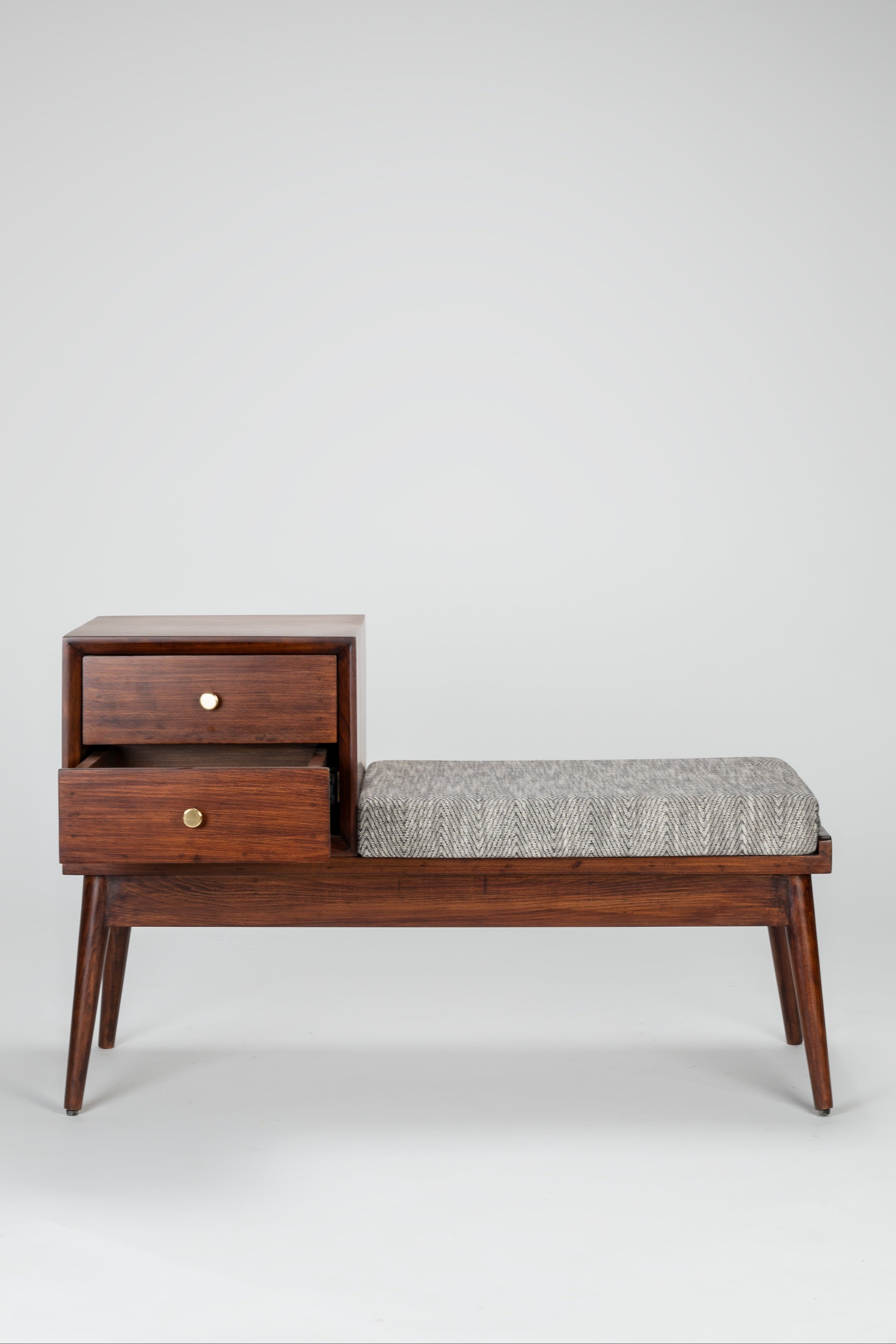 Wooden bench with storage drawers and a cushion on a plain background