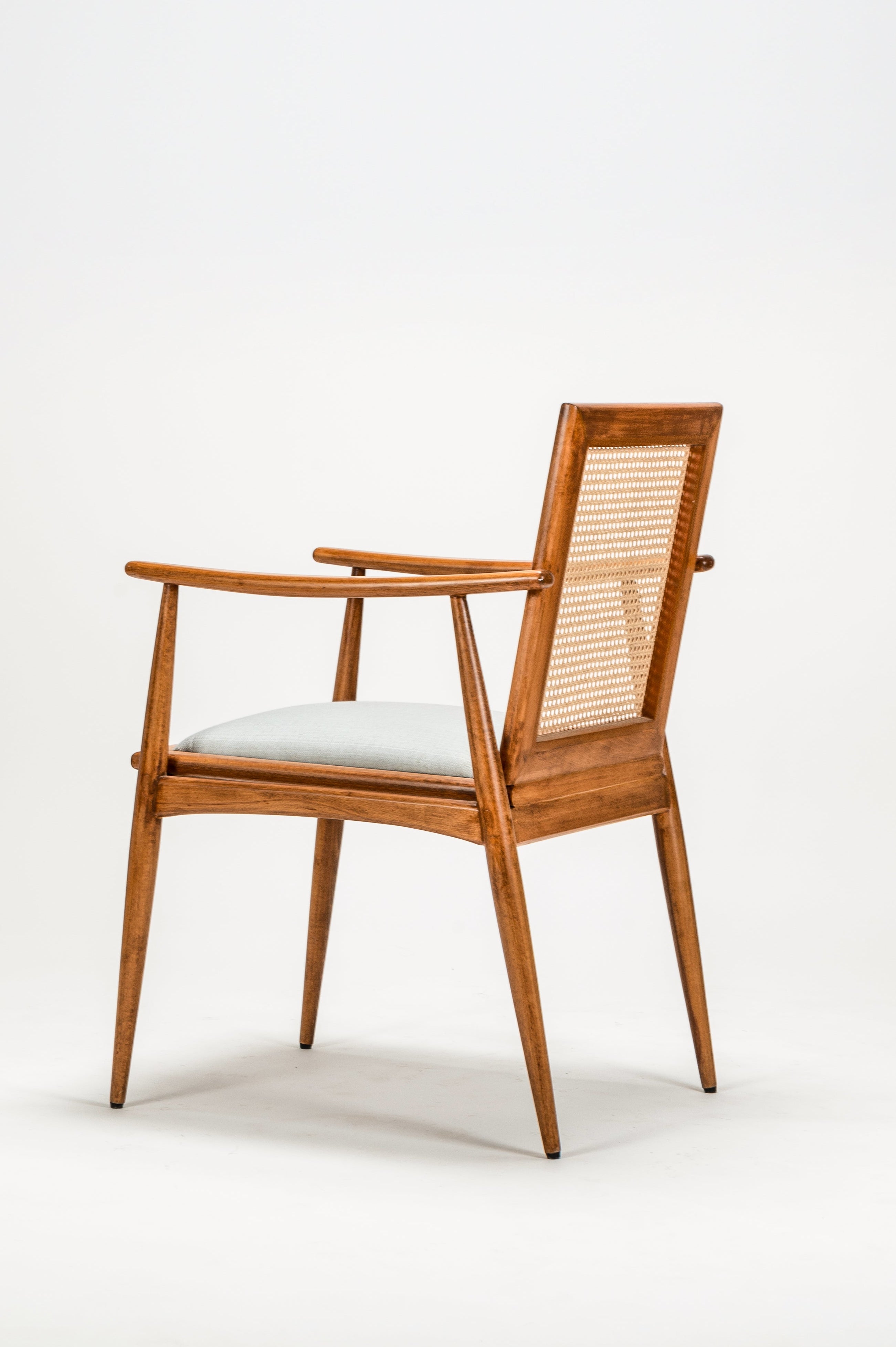 Wooden chair with a white cushion on a light gray background