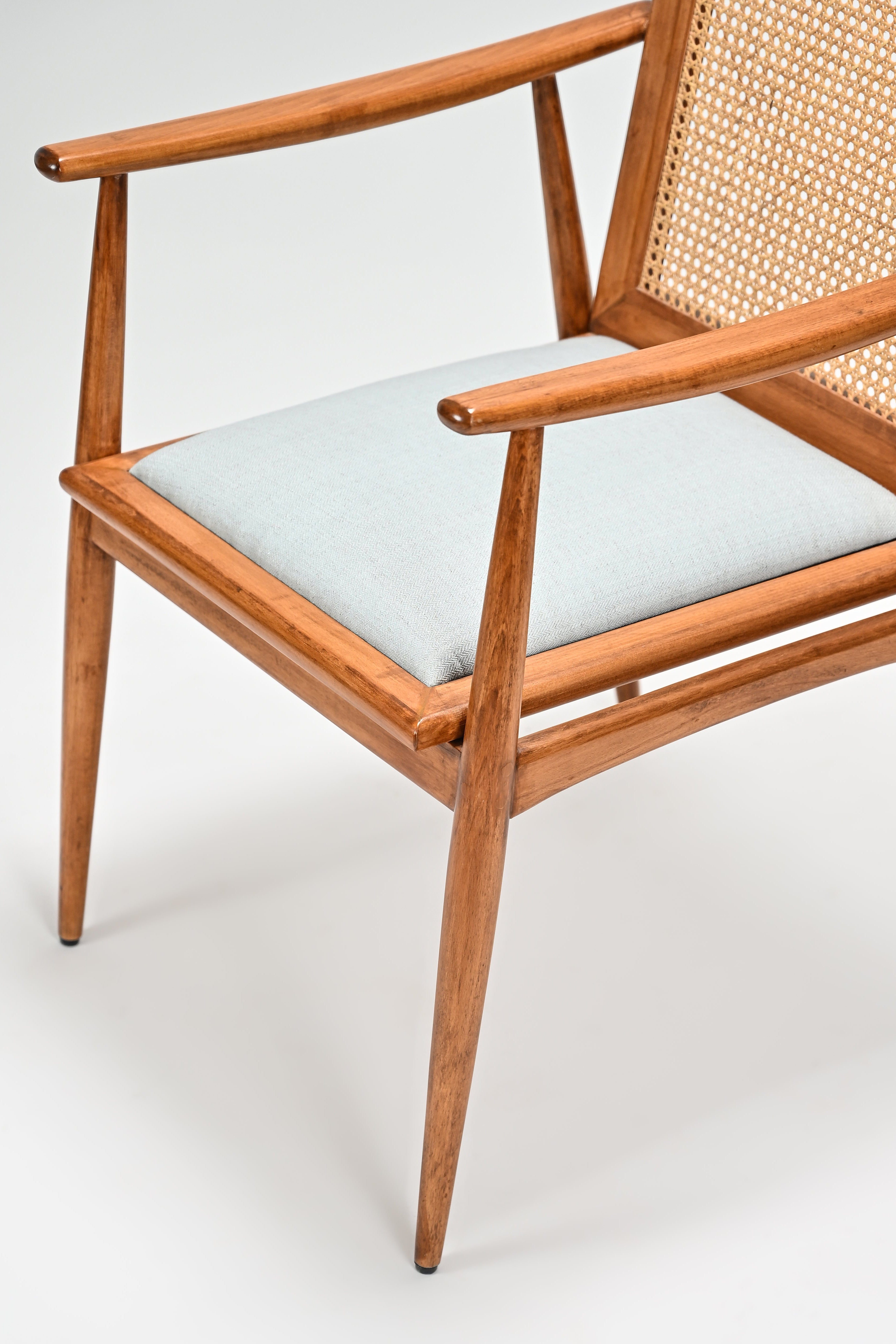 Wooden chair with light blue cushion on a white background
