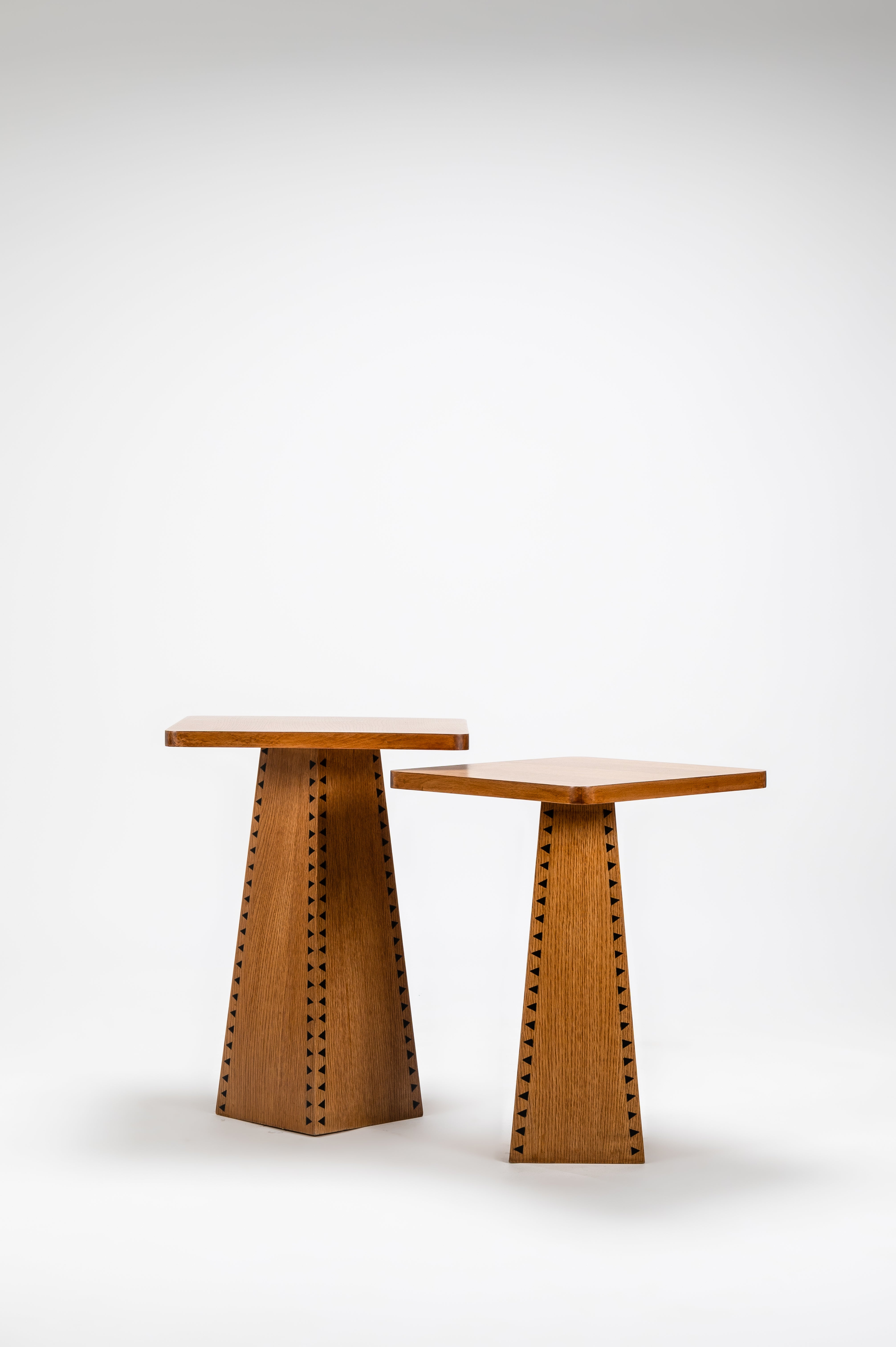 Two wooden stools with unique designs on a white background