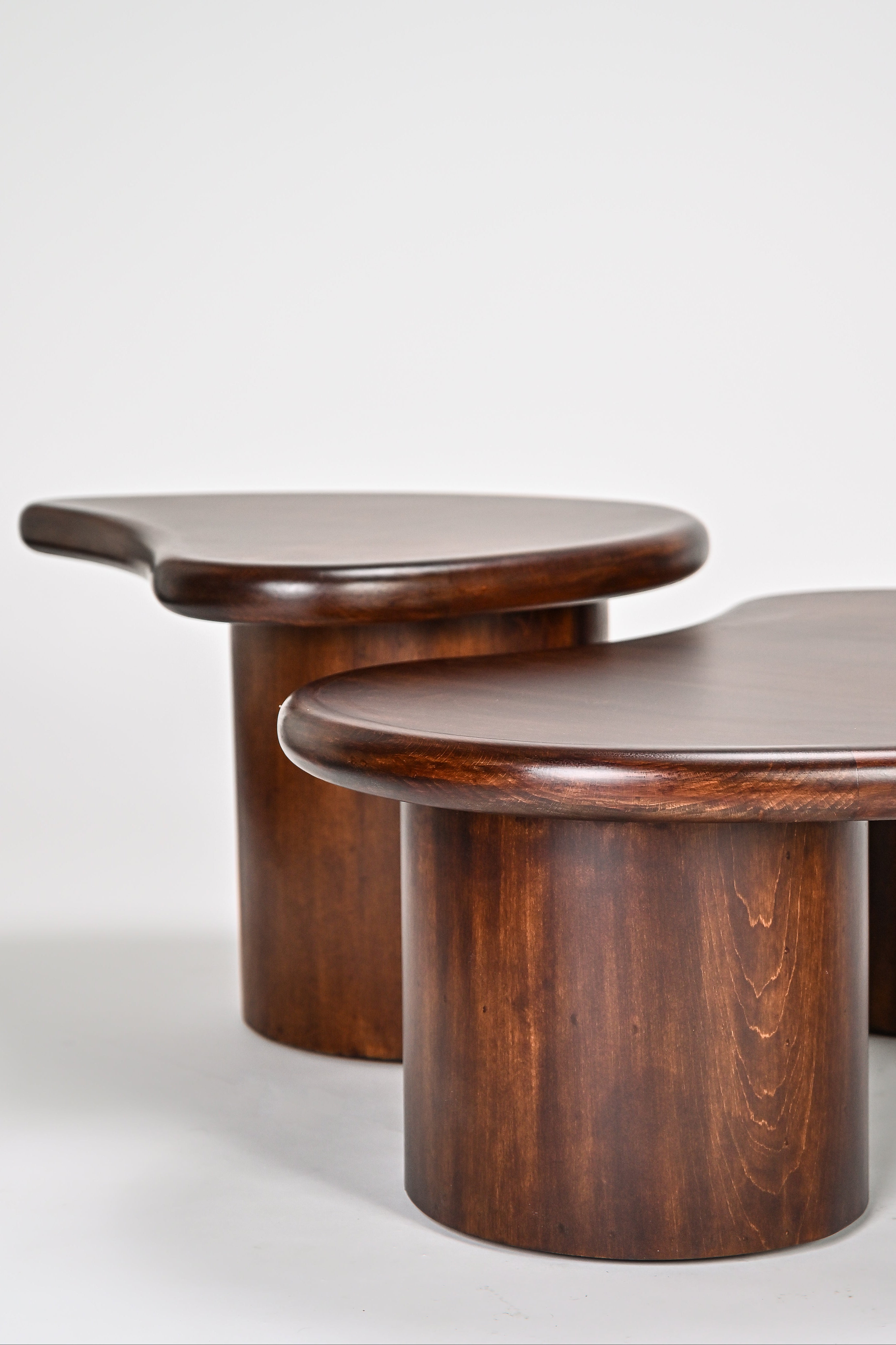 Two wooden tables with a minimalist design on a white background