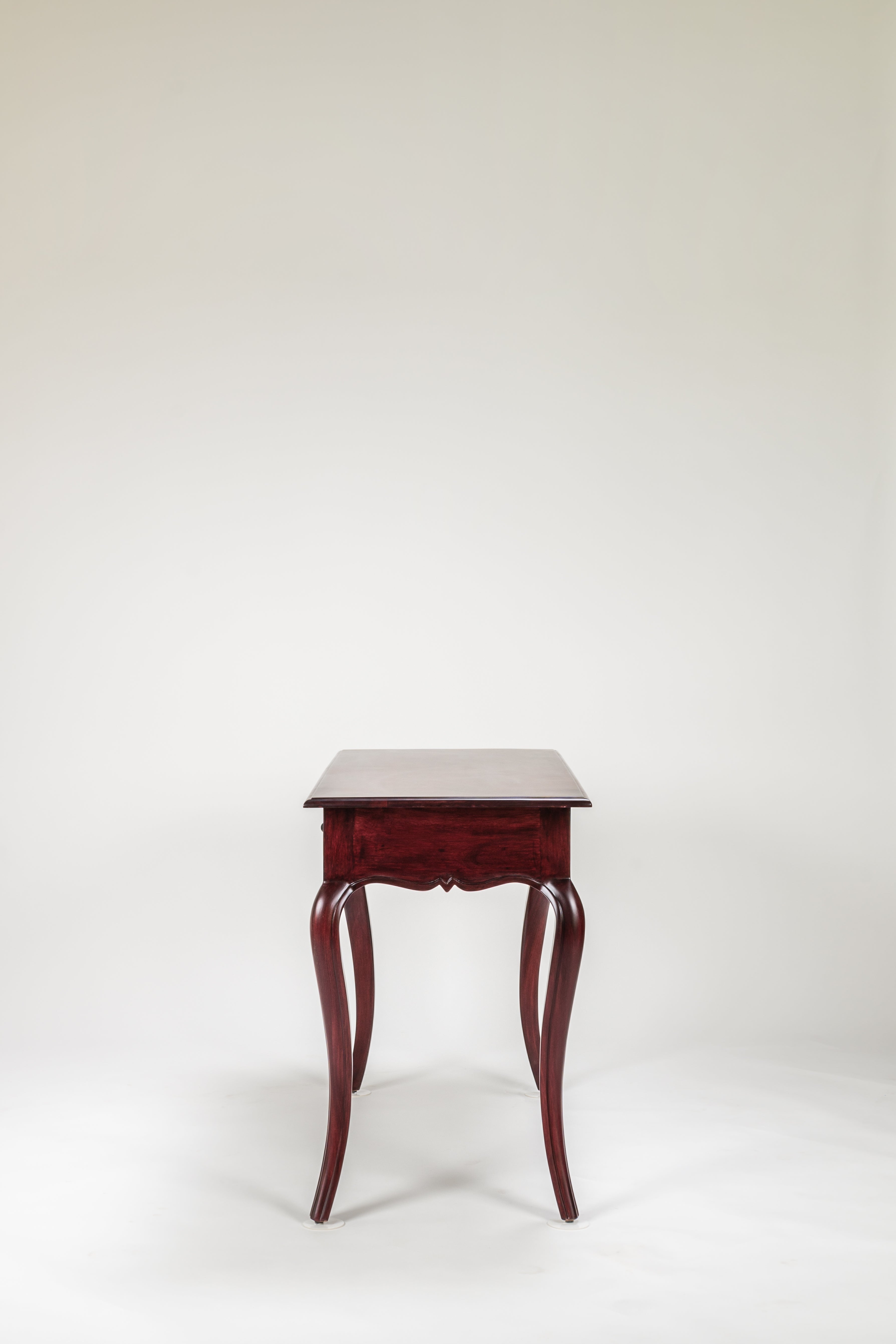 Wooden side table with curved legs on a white background