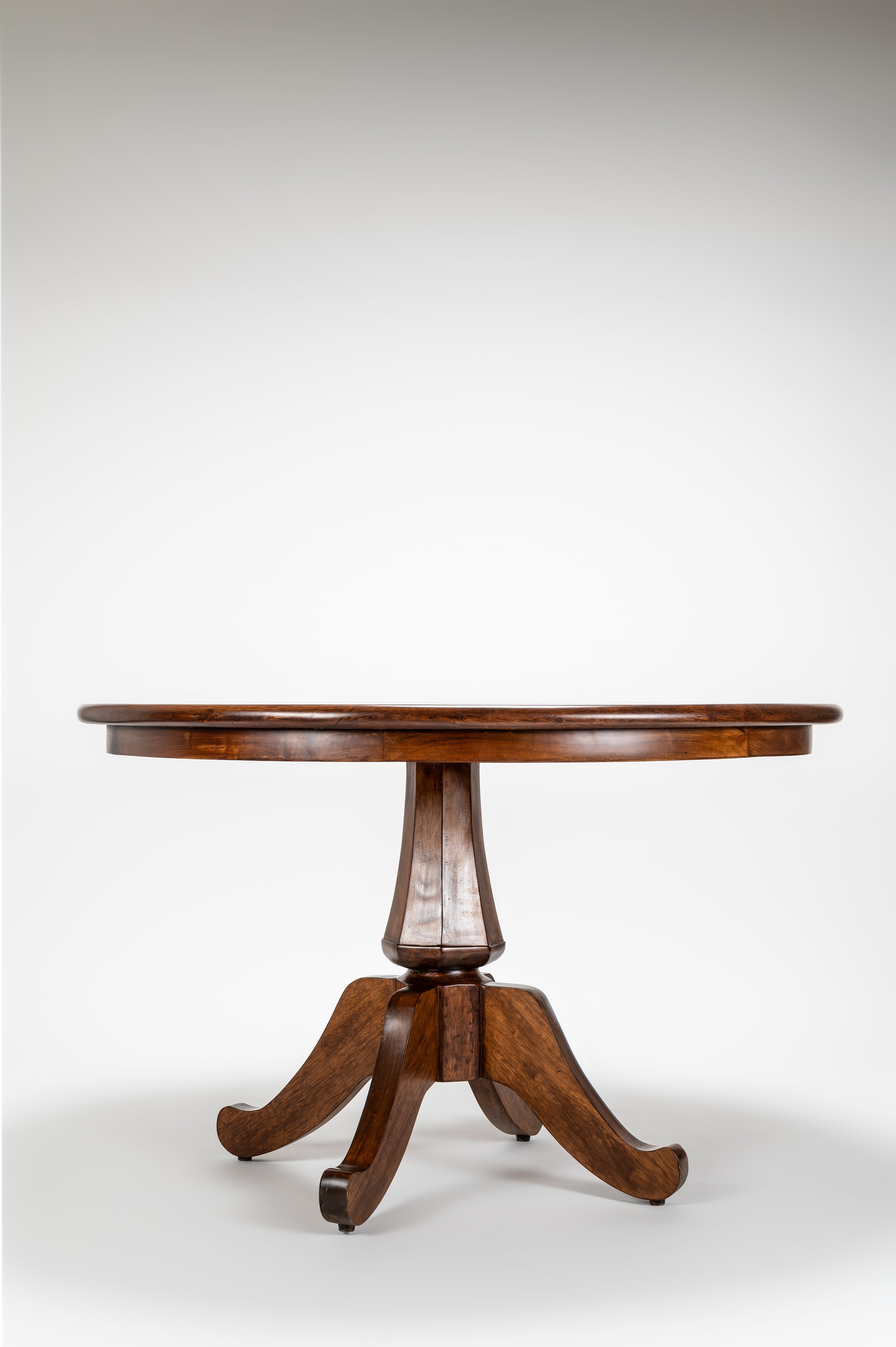 Wooden round table with a pedestal base on a white background