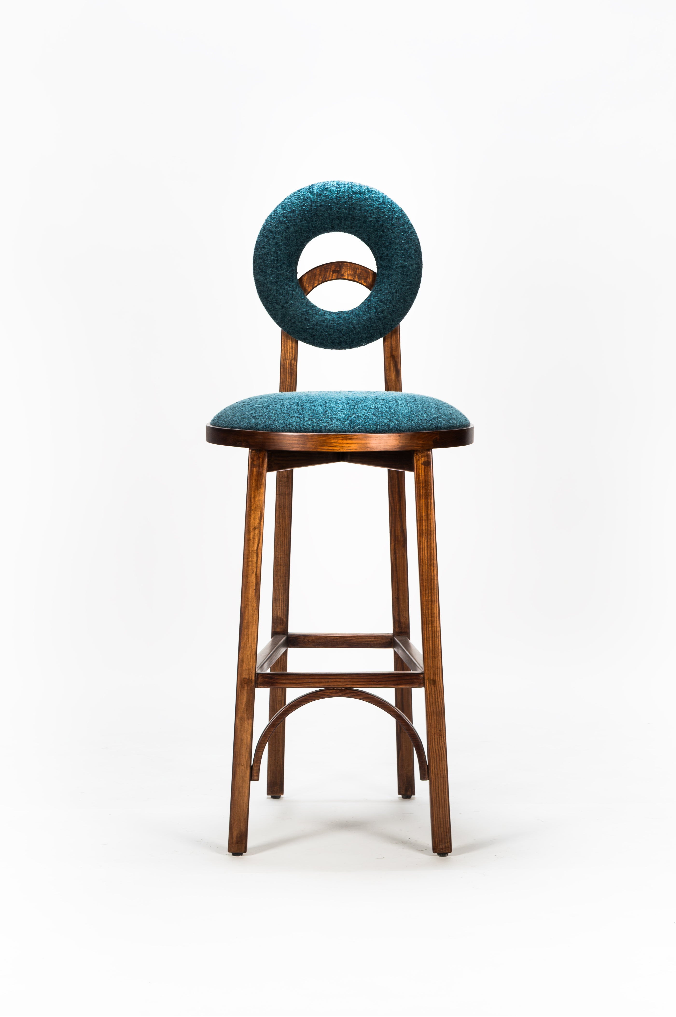 Bar stool with teal cushioned backrest and seat on a white background