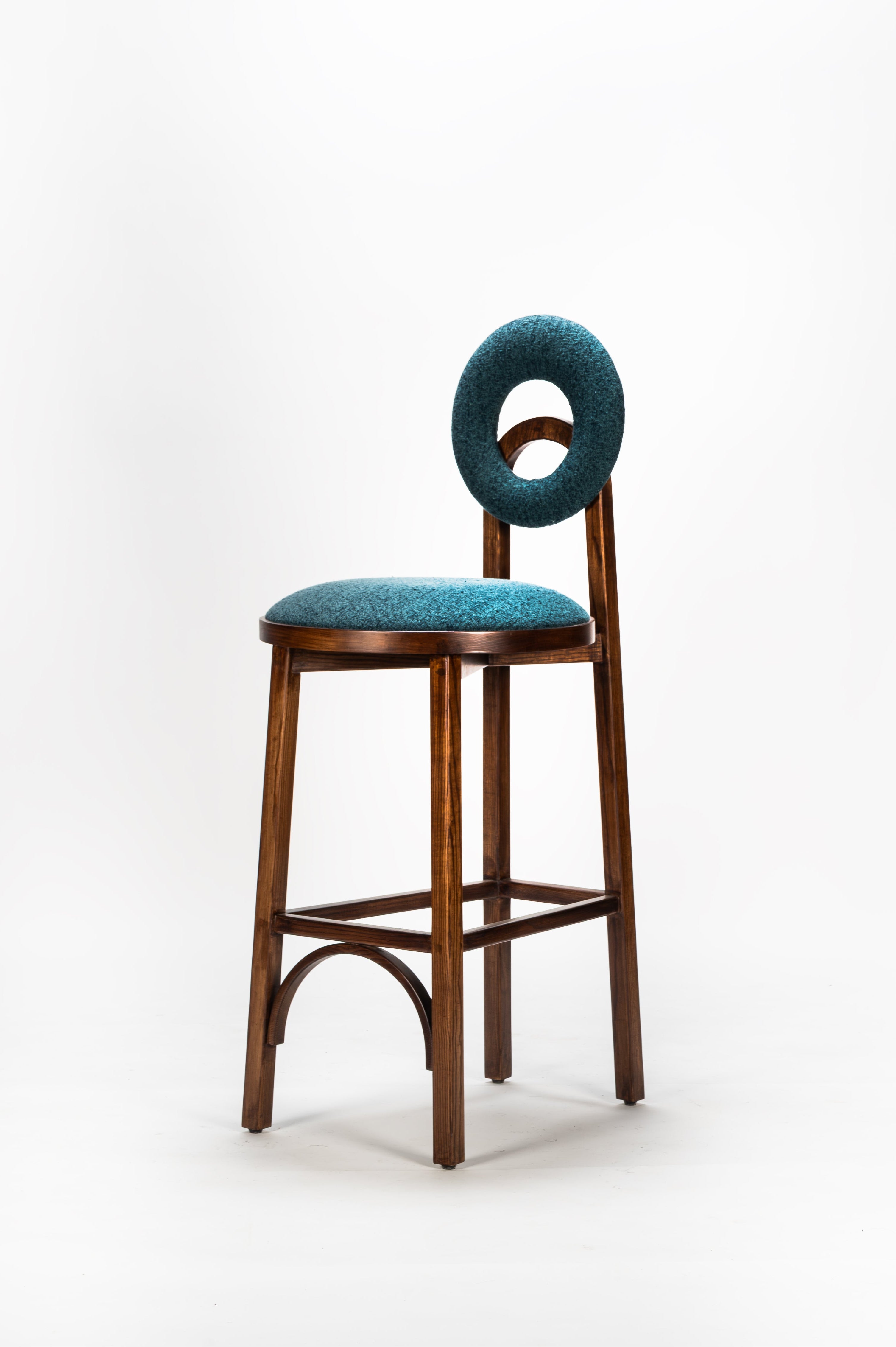 Bar stool with teal cushioned backrest and seat on a white background