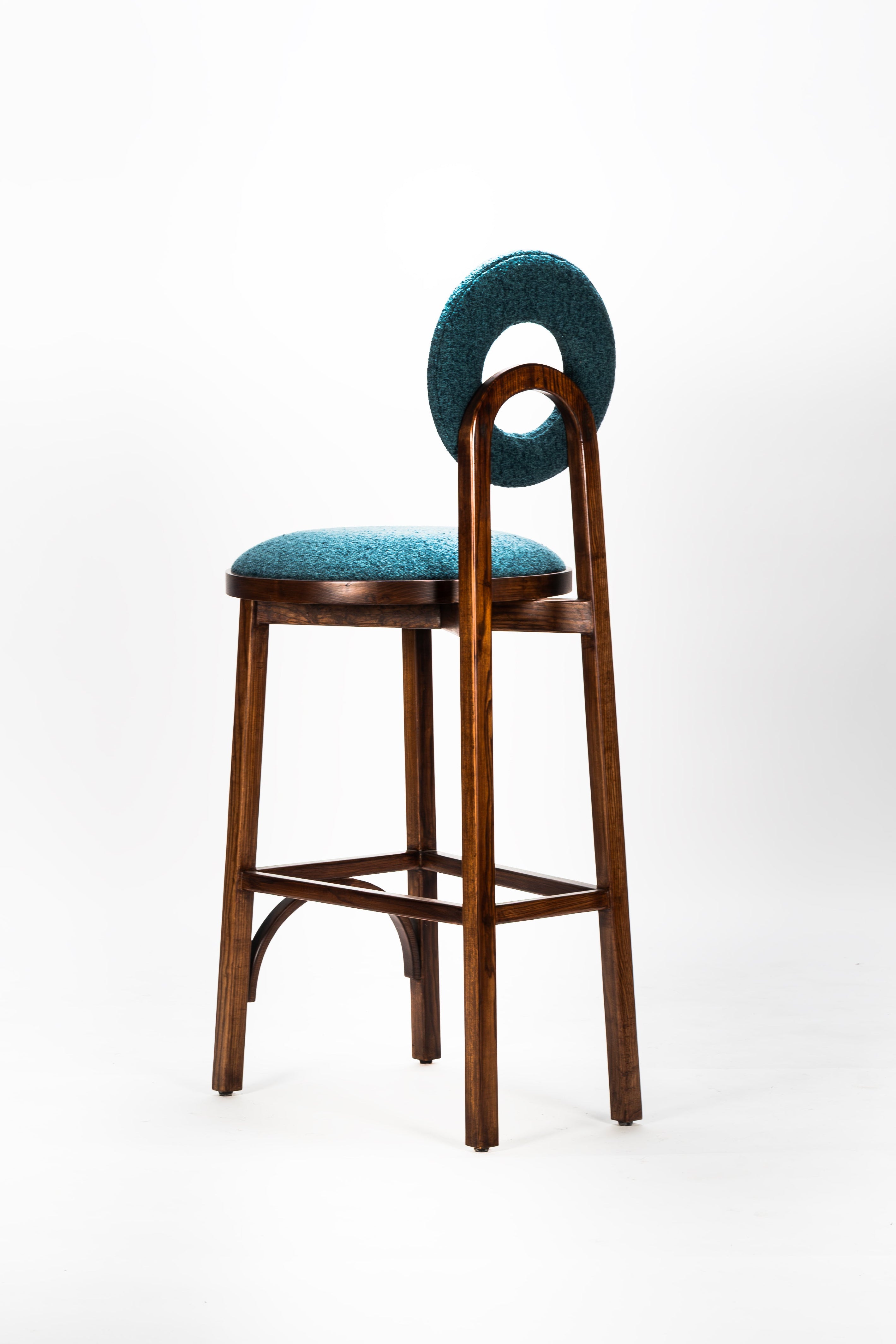Bar stool with blue cushioned seat and backrest on a white background