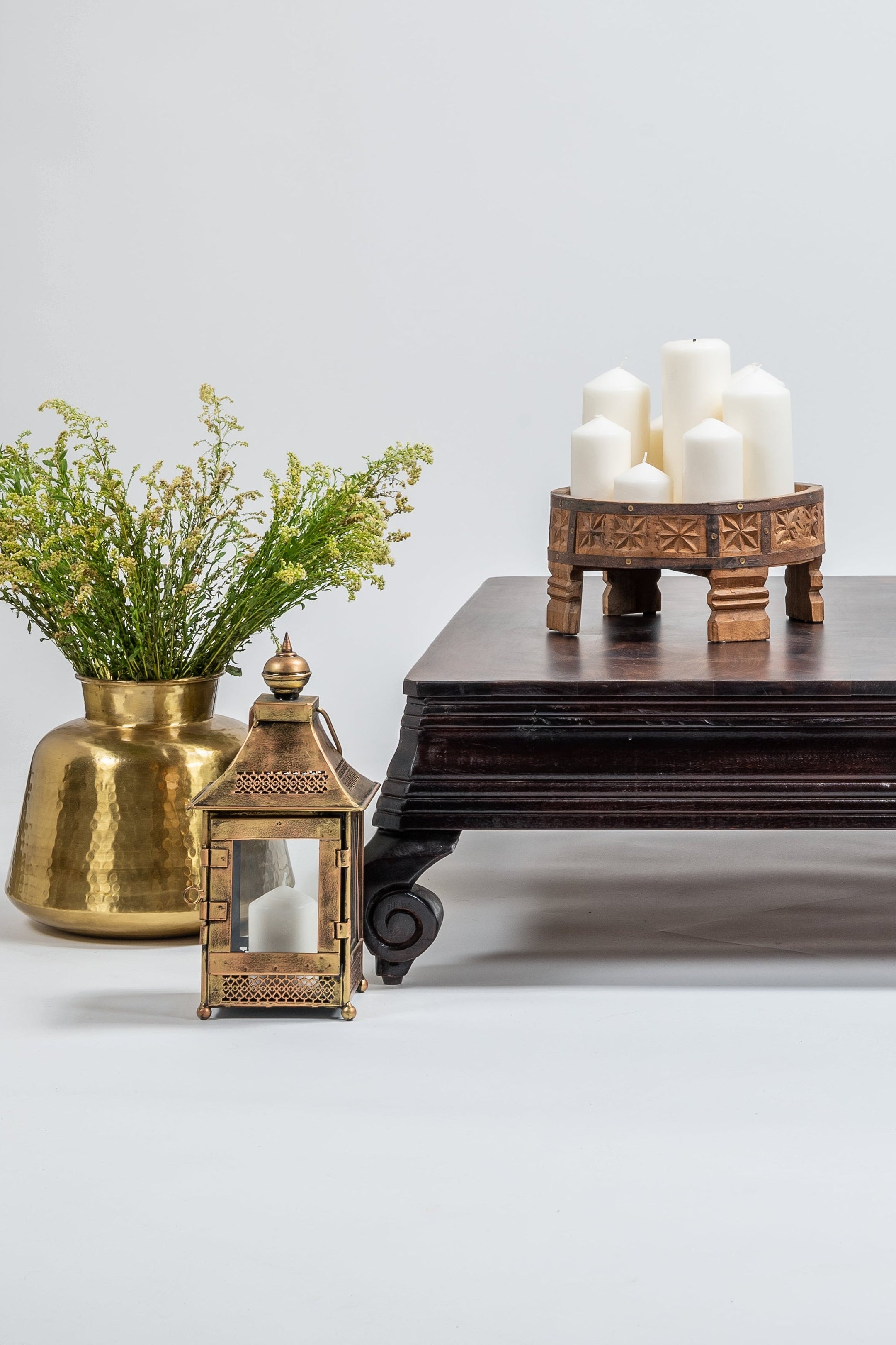 Traditional wooden table with decorative items on a plain background