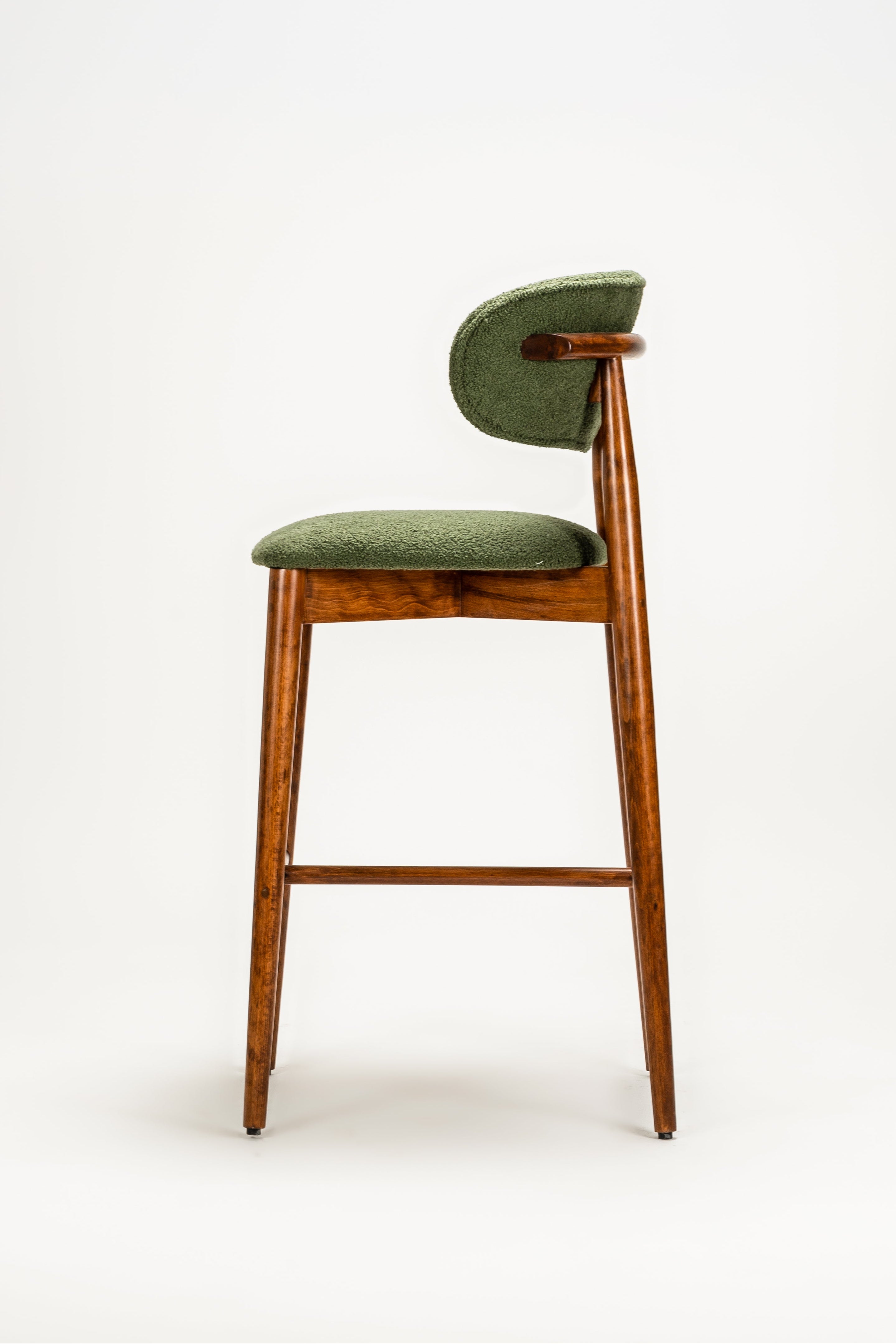 Green cushioned stool with wooden legs on a white background