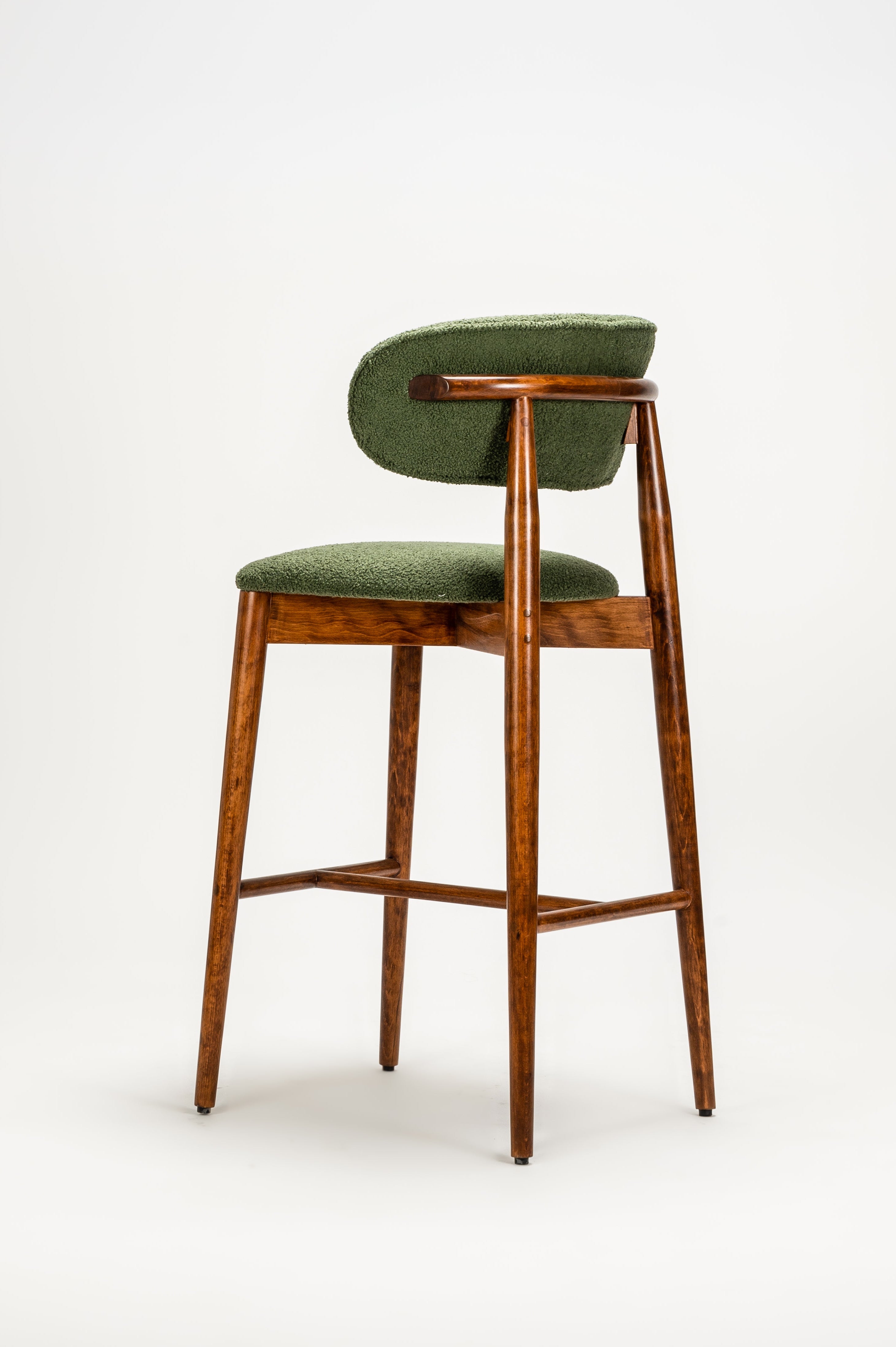 Green cushioned bar stool with wooden legs on a white background