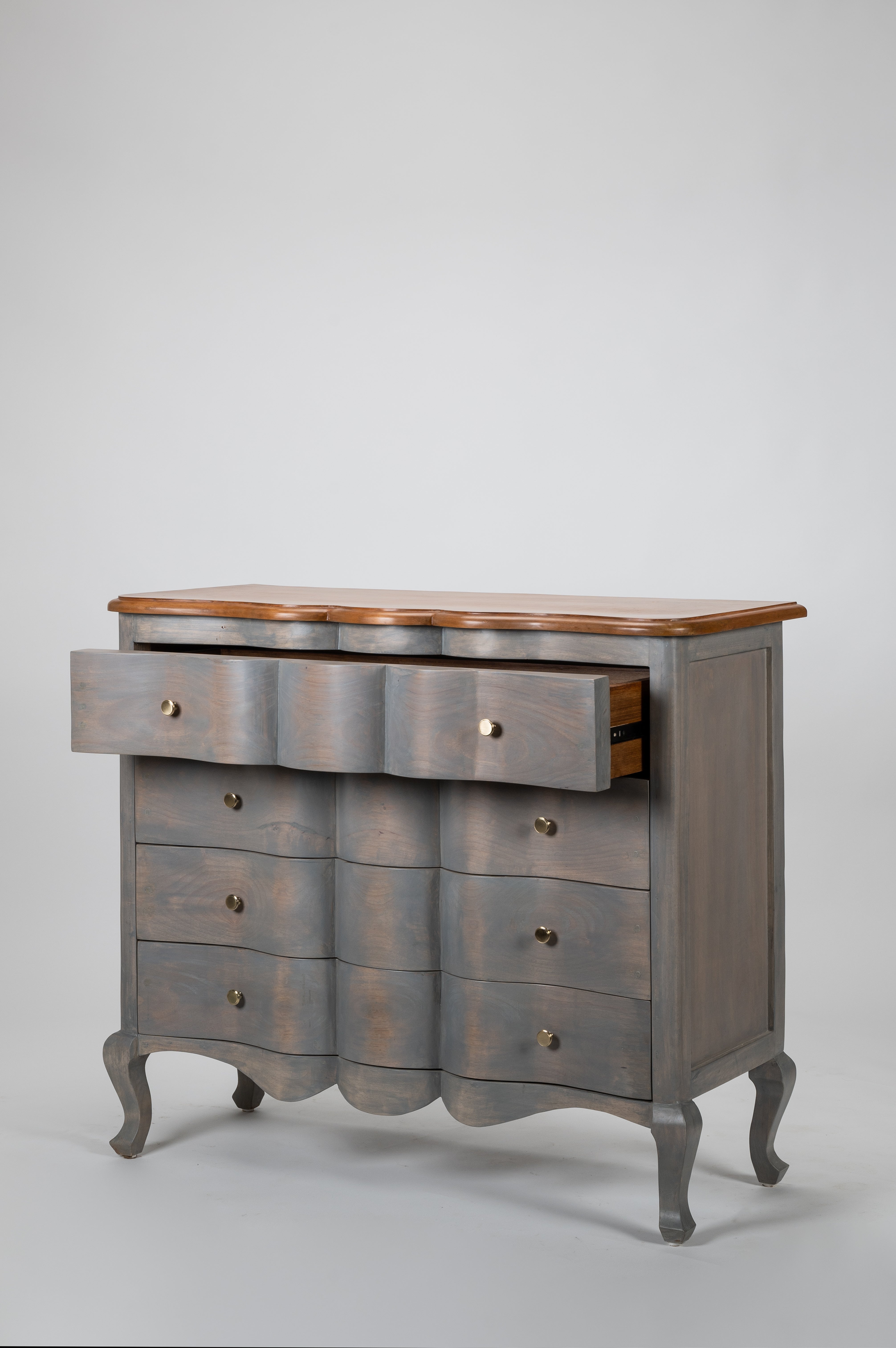 Wooden dresser with a gray finish and wooden top on a light gray background