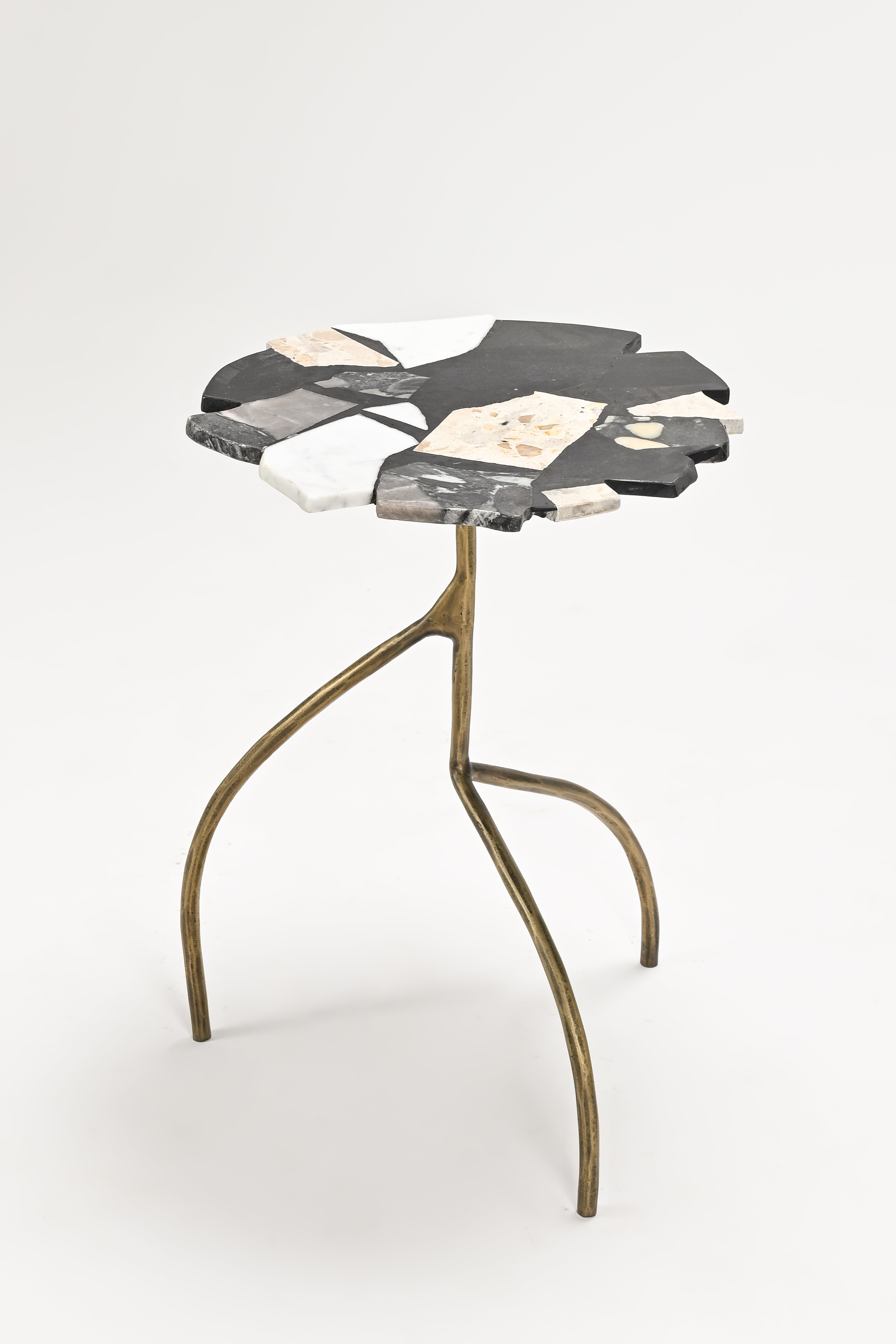 Small side table with a marble-like top and brass legs on a white background