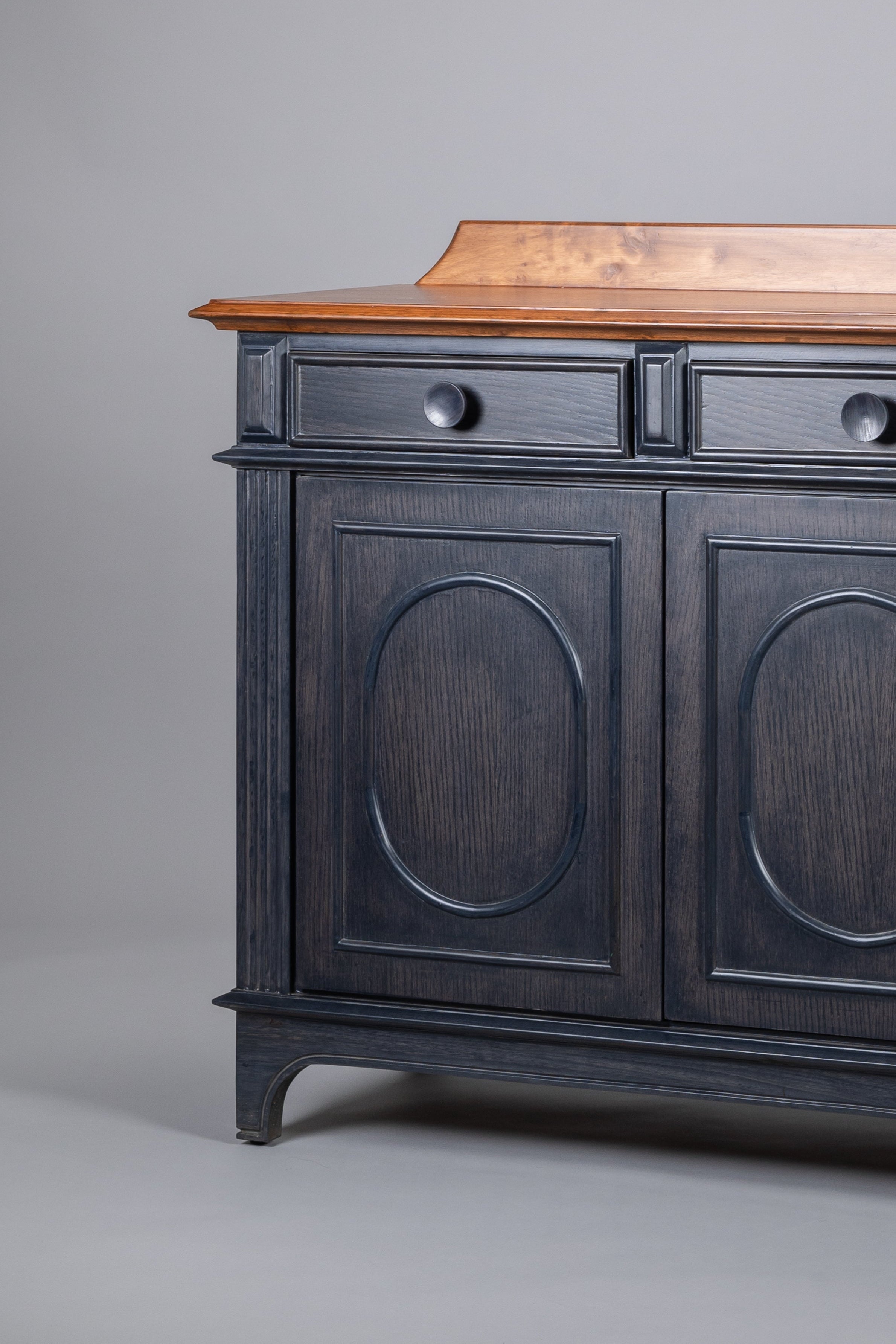 Wooden cabinet with black painted doors on a gray background
