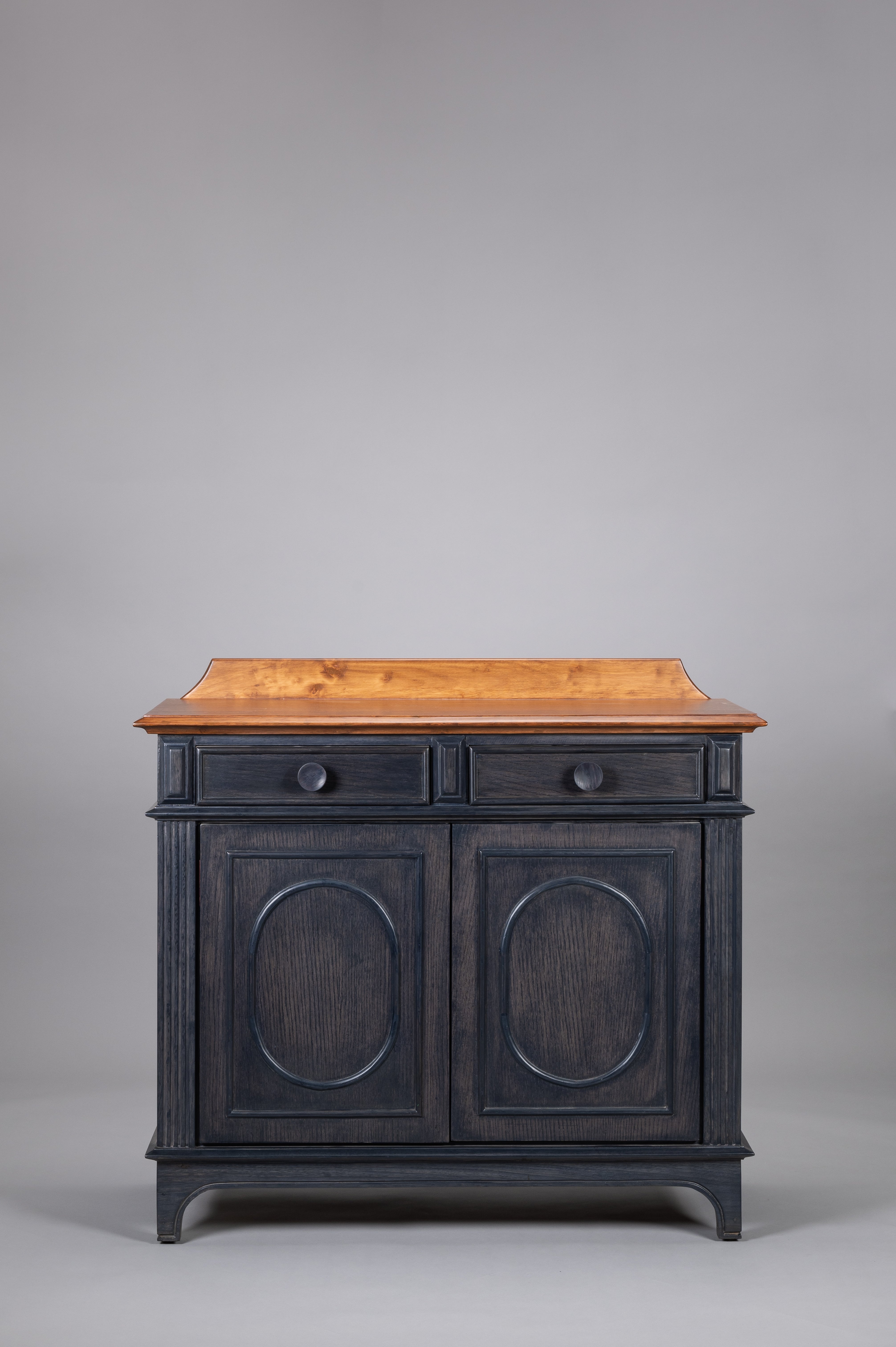 Wooden cabinet with black painted doors on a gray background
